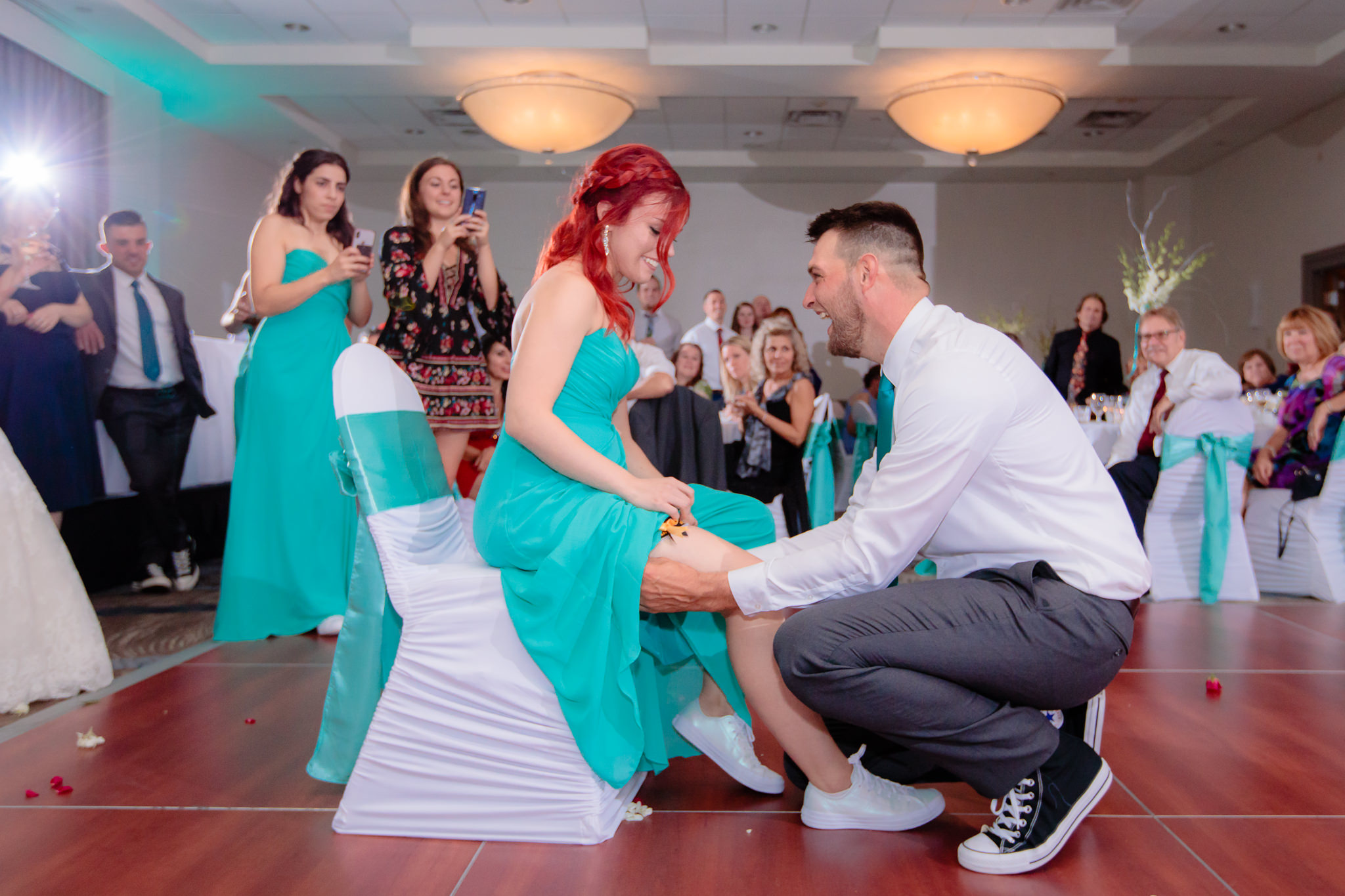 Best man puts the garter on the maid of honor at Pittsburgh Airport Marriott