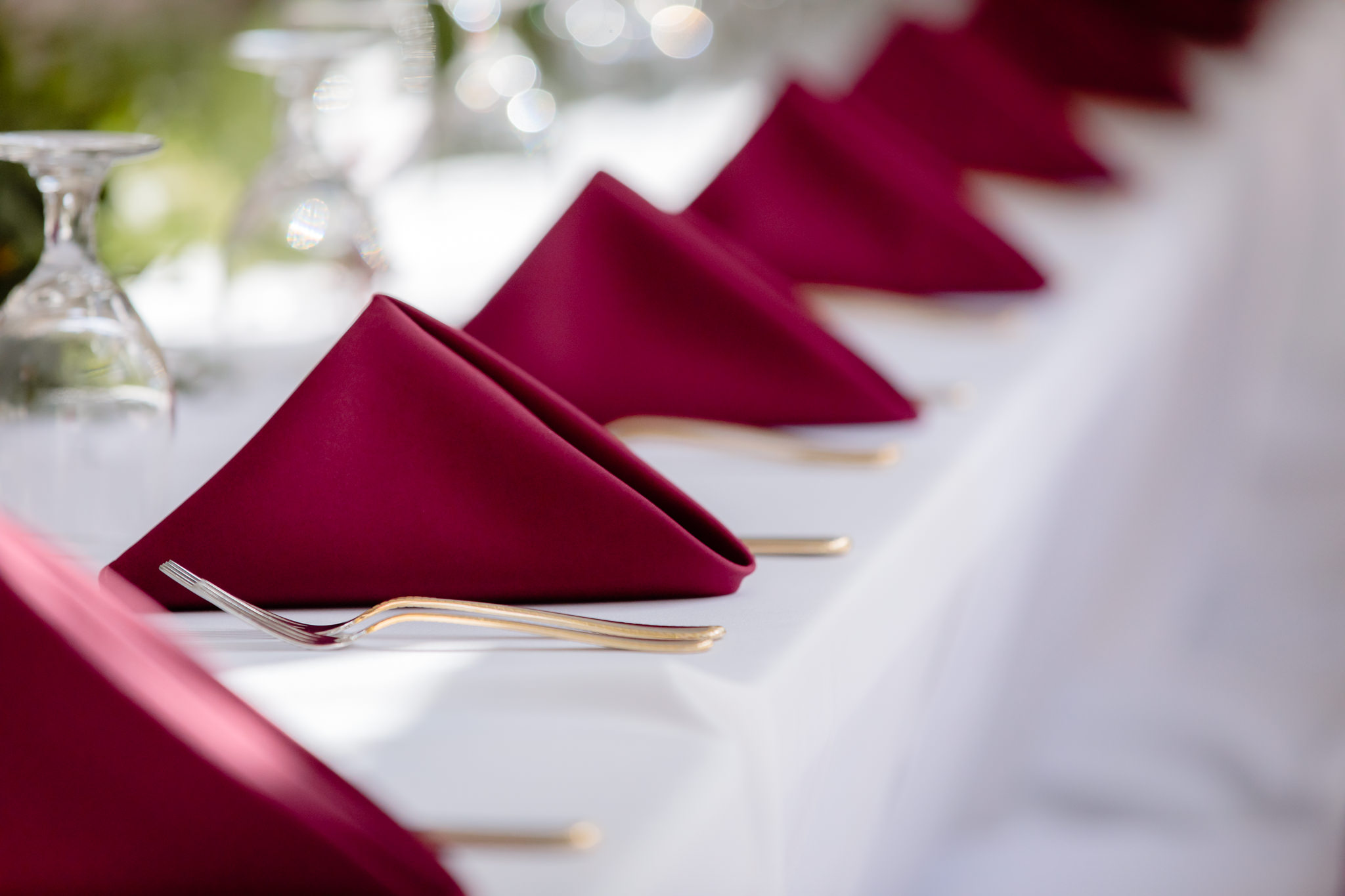 Burgundy napkins and gold flatware on the head table at Greystone Fields