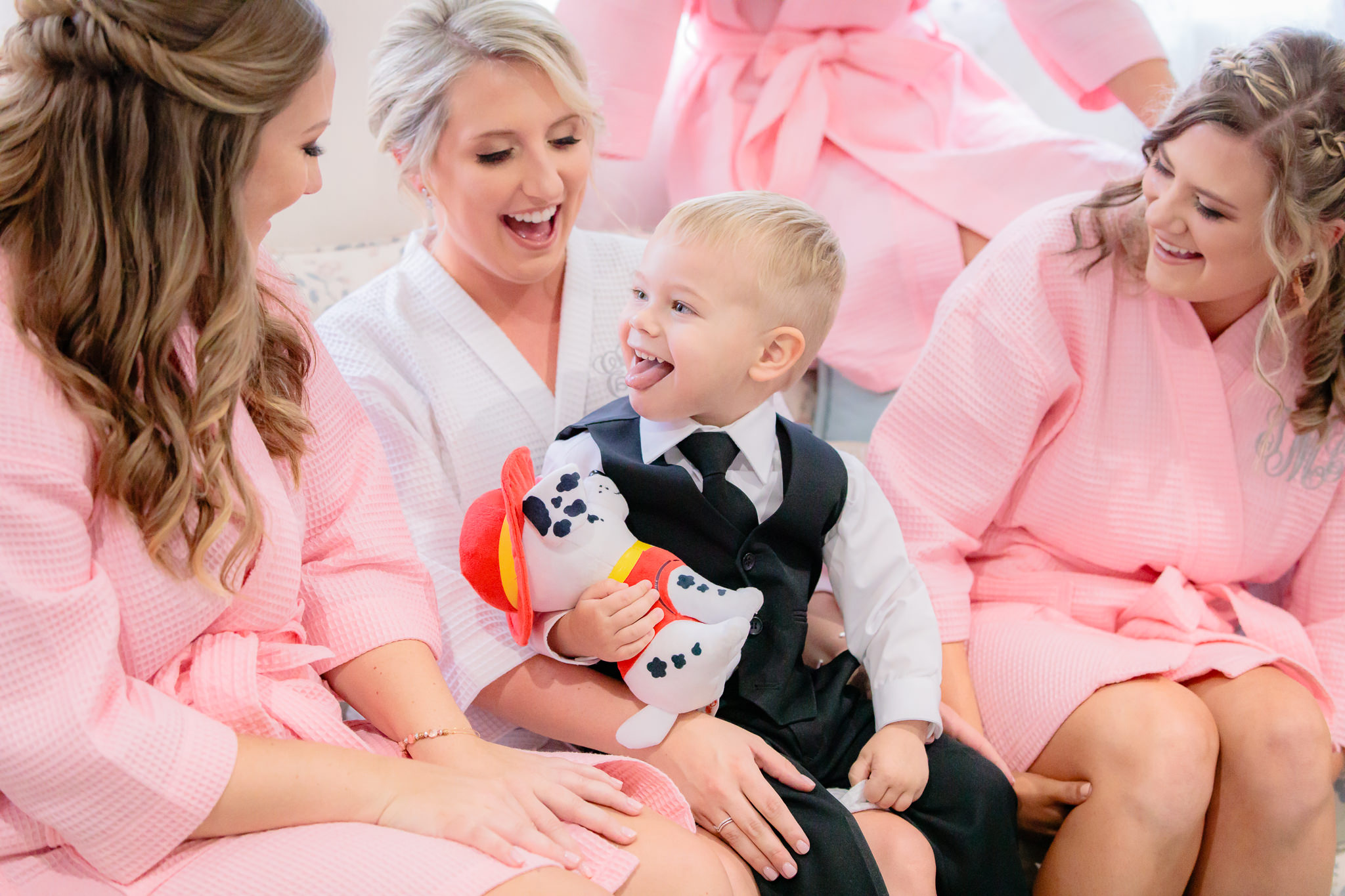 Ring bearer laughs with bridesmaids at a Greystone Fields wedding