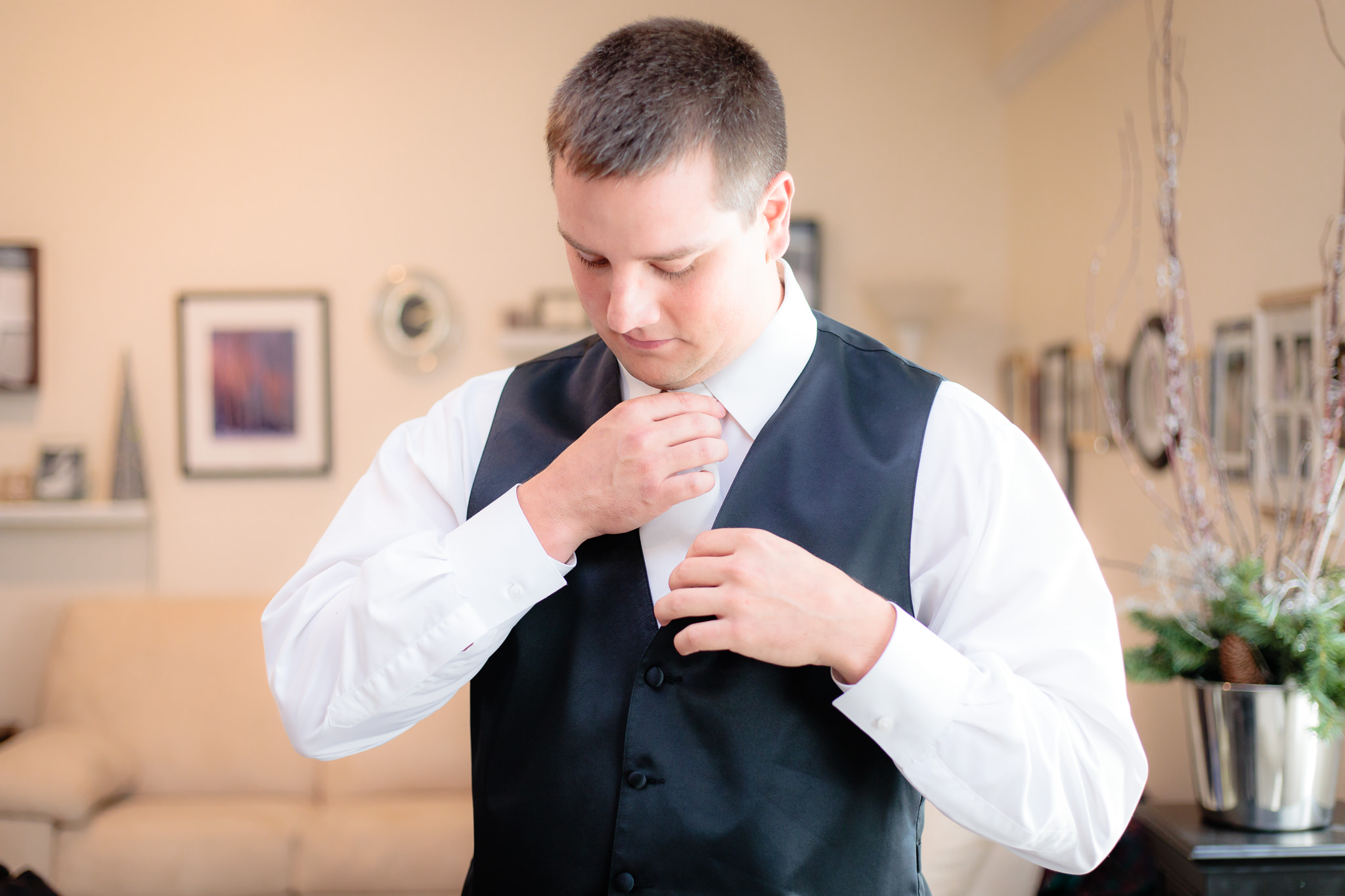 Groom straightens his tie before a Greystone Fields wedding