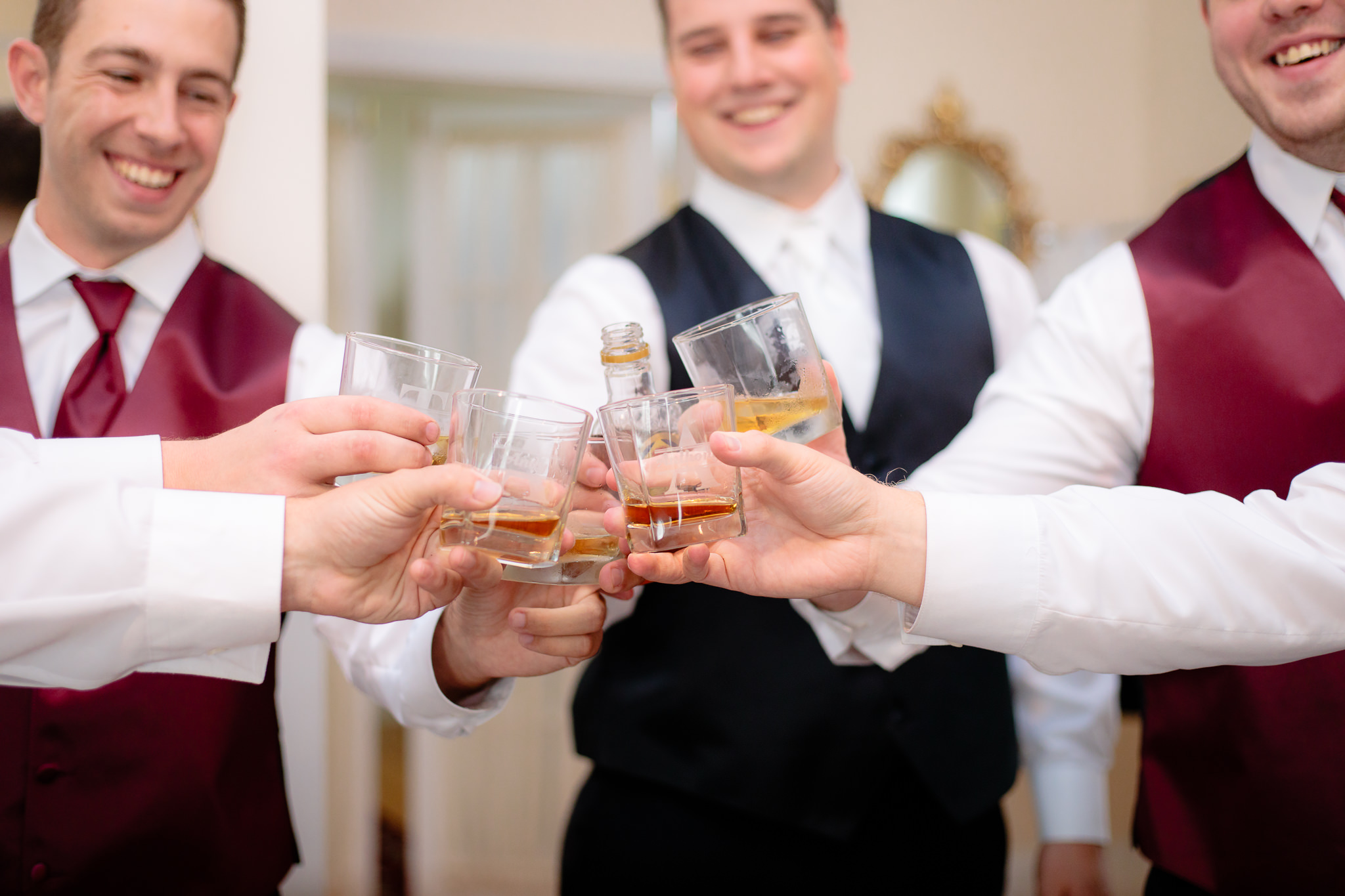 Groom & groomsmen cheers with shots of whiskey before a Greystone Fields wedding