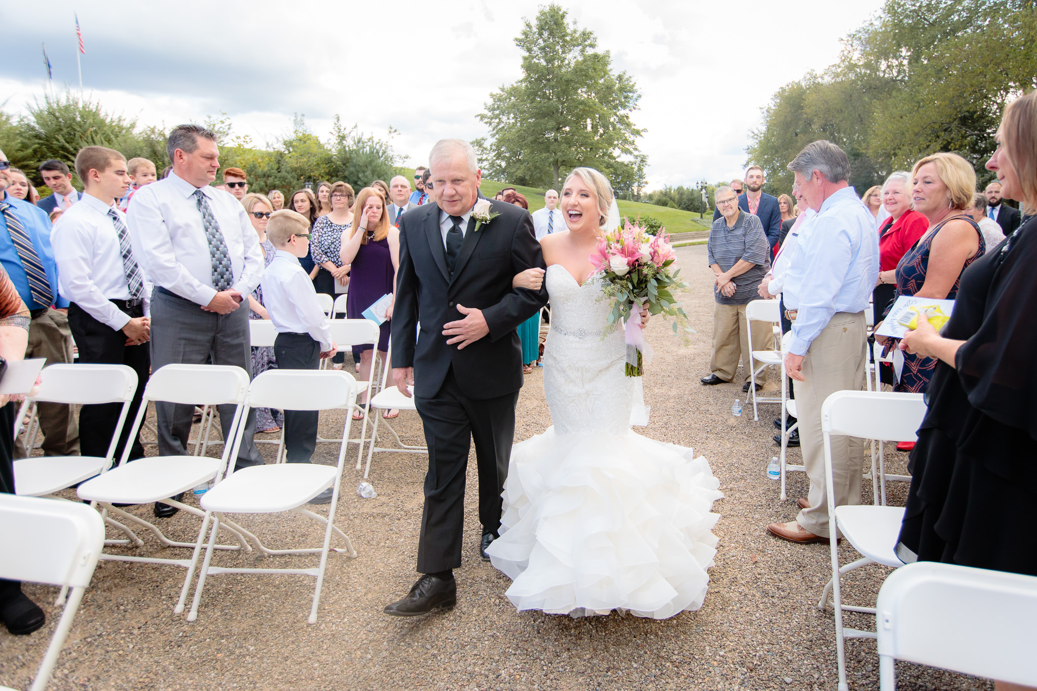Bride excitedly approaches the groom at an outdoor wedding at Greystone Fields