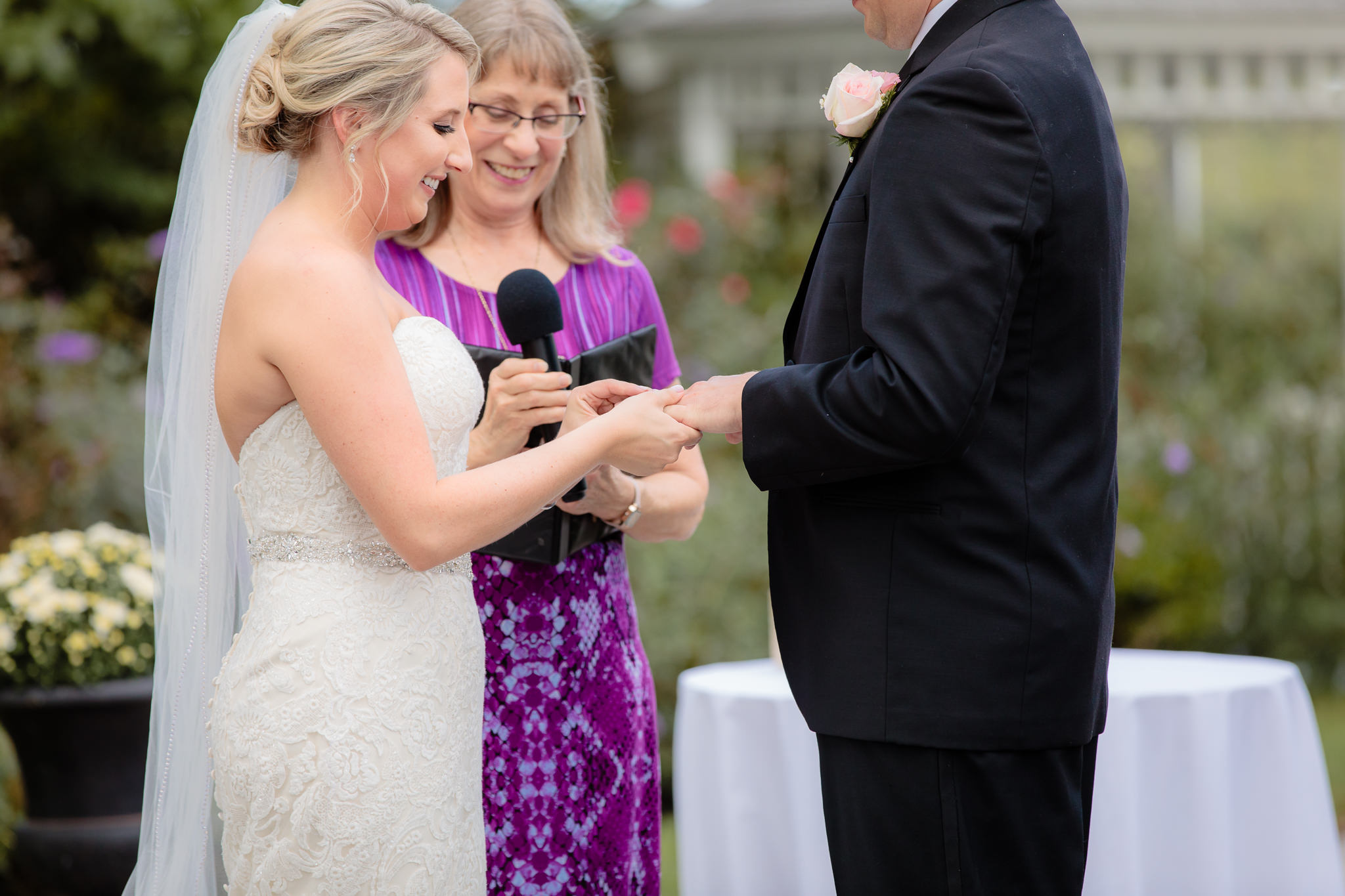 Bride puts the ring on the groom's finger at Greystone Fields