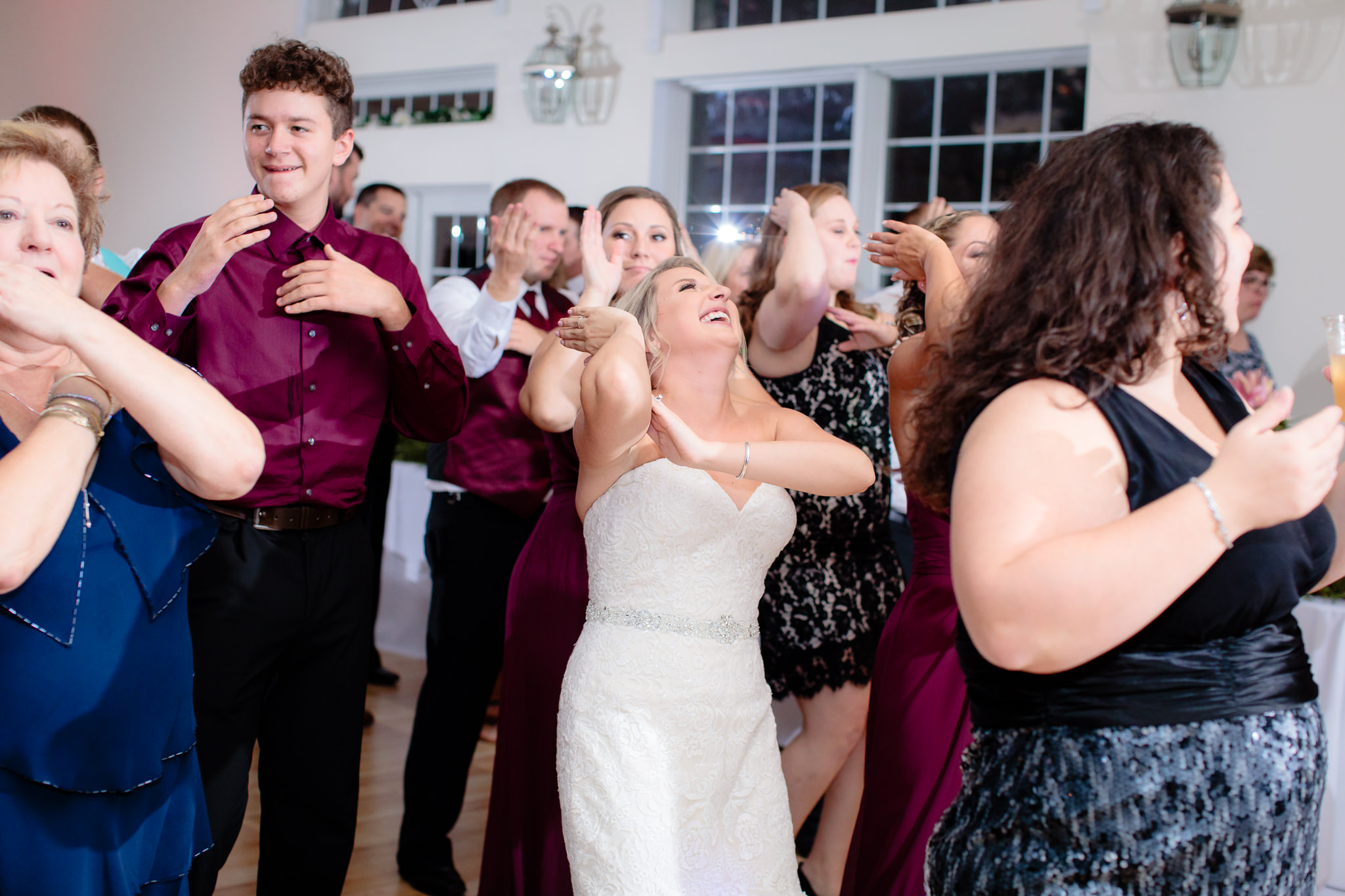 Bride laughs during a line dance at a Greystone Fields wedding