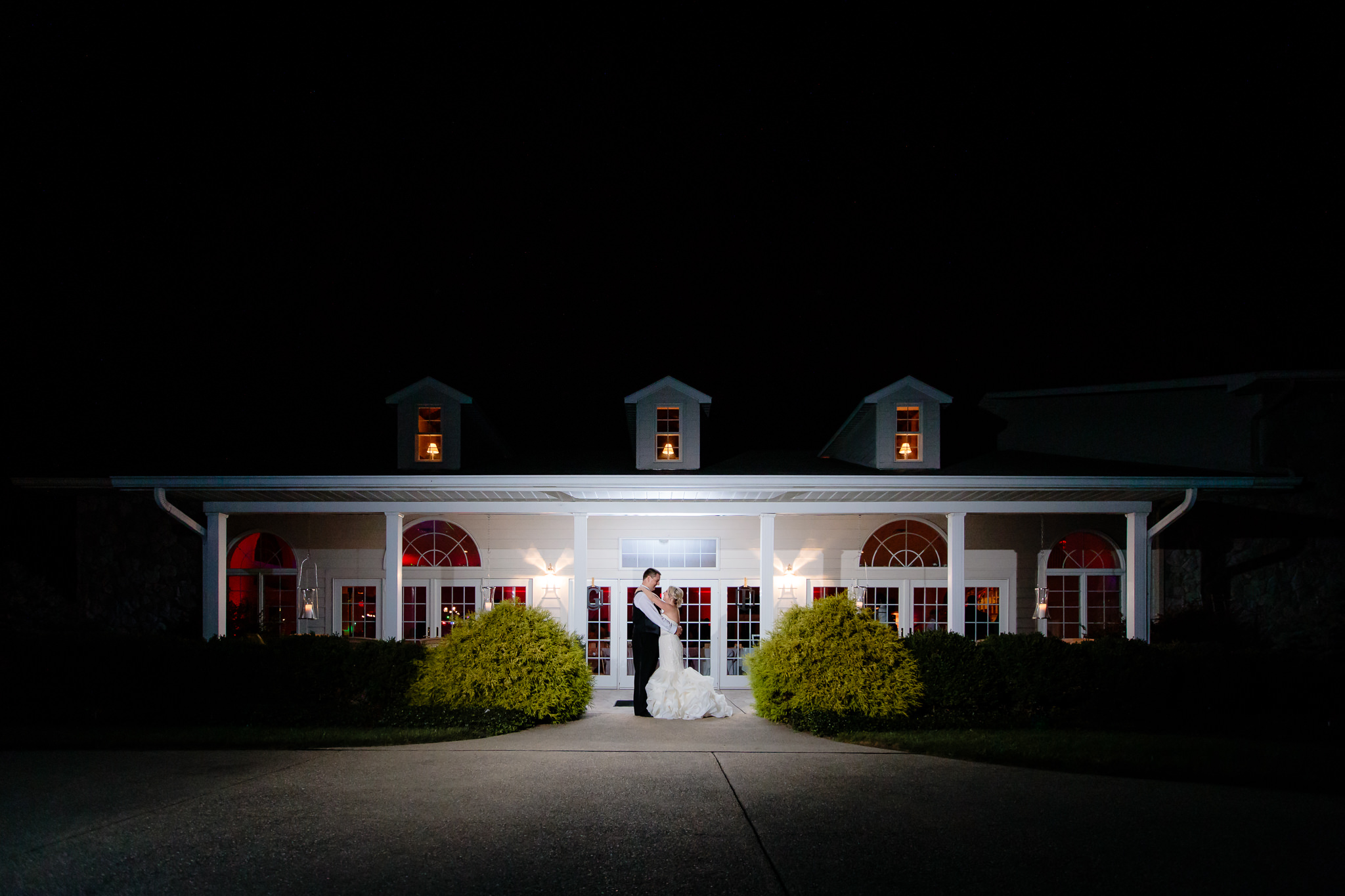 Night shot of bride and groom in front of Greystone Fields in Gibsonia