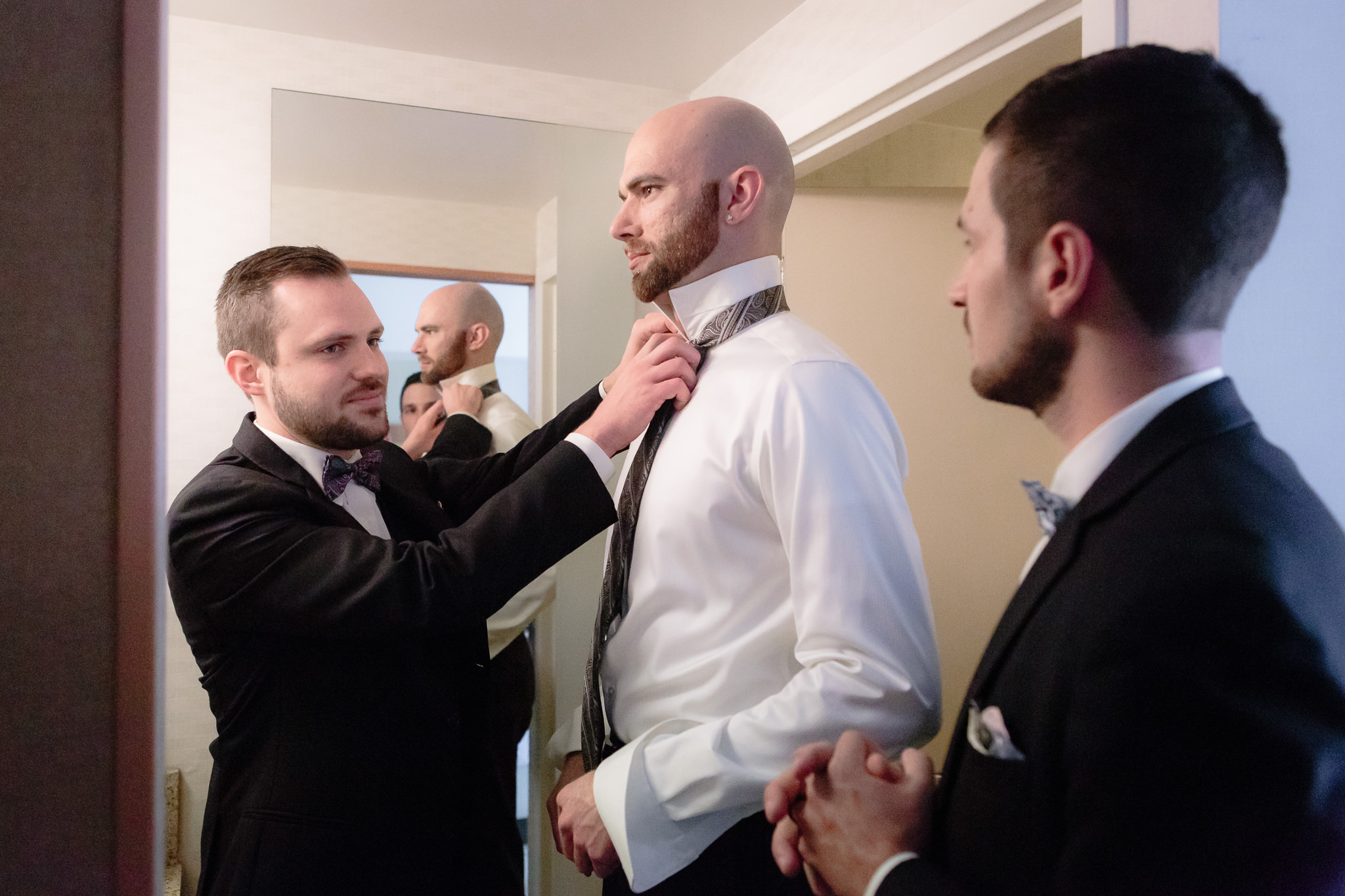 Groomsmen ties groom's tie before his National Aviary wedding