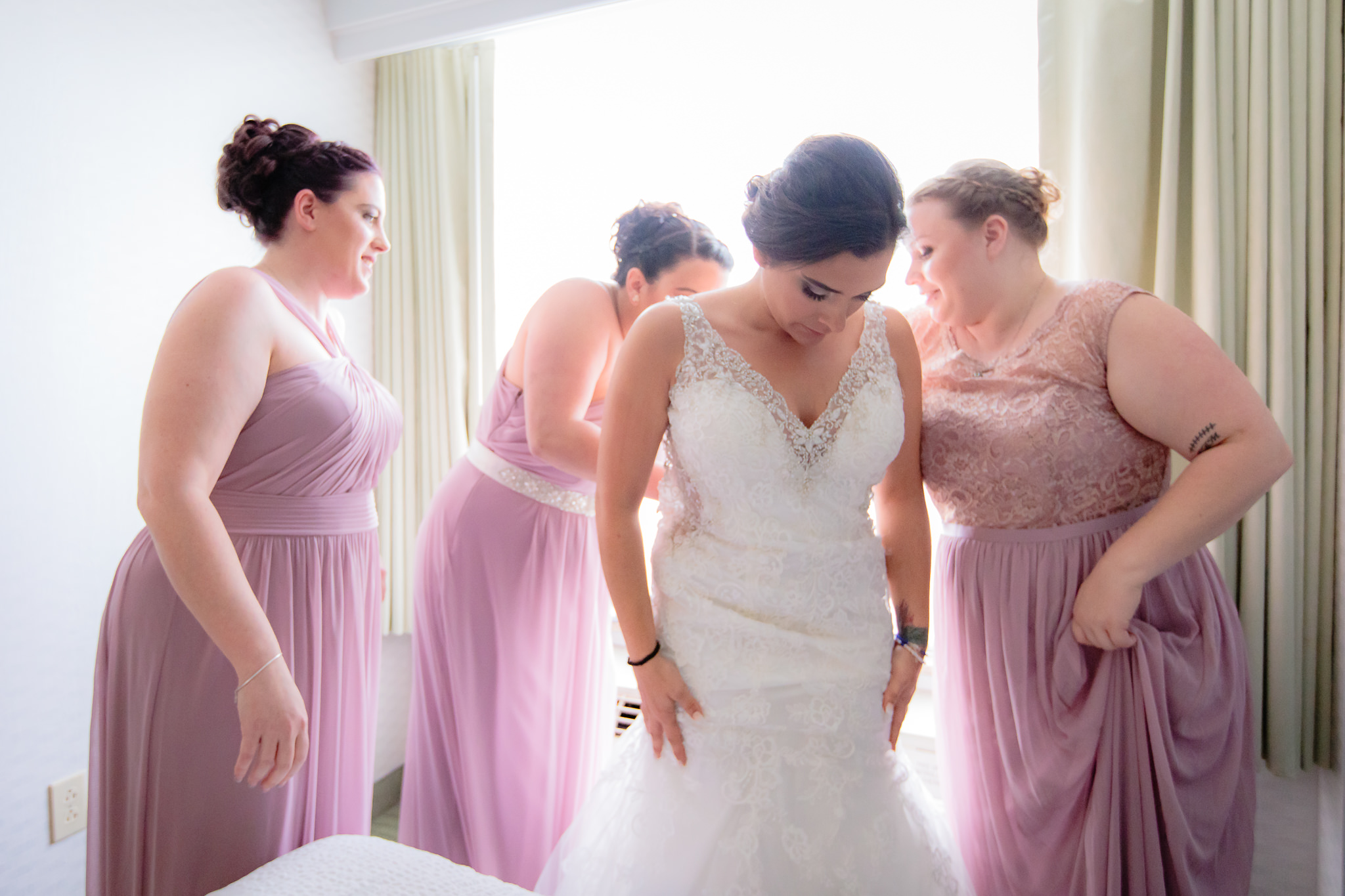 Bridesmaids help the bride into her wedding dress before a National Aviary wedding