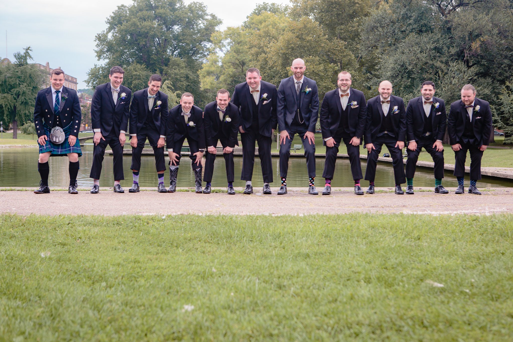 Groomsmen show off their socks in Allegheny Commons Park before a National Aviary wedding