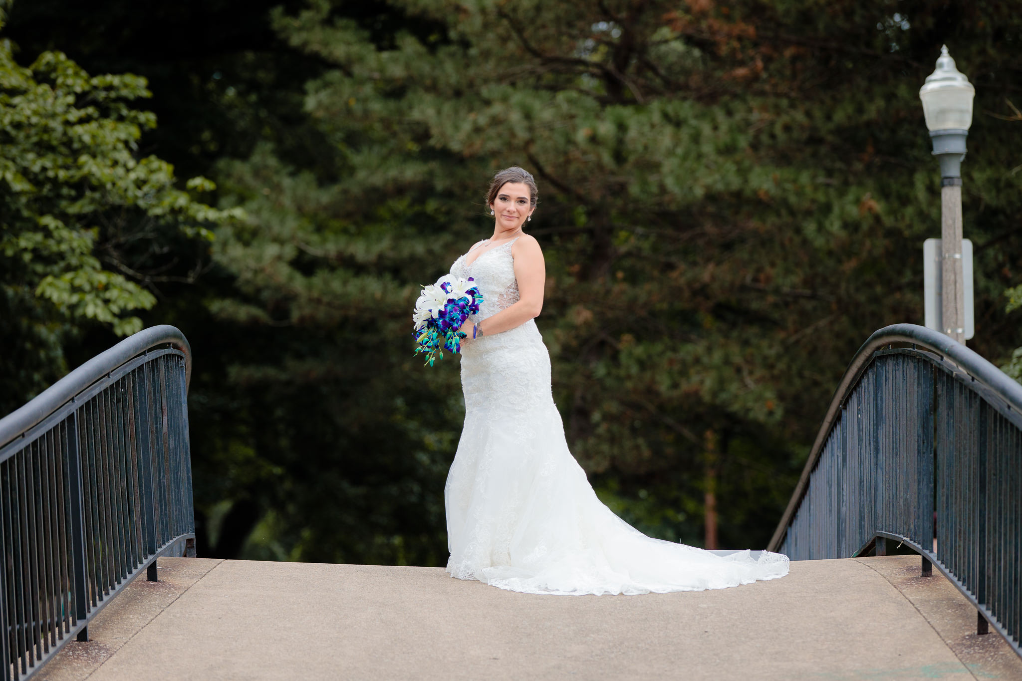 Bride poses on a bridge in Allegheny Commons Park before her National Aviary wedding