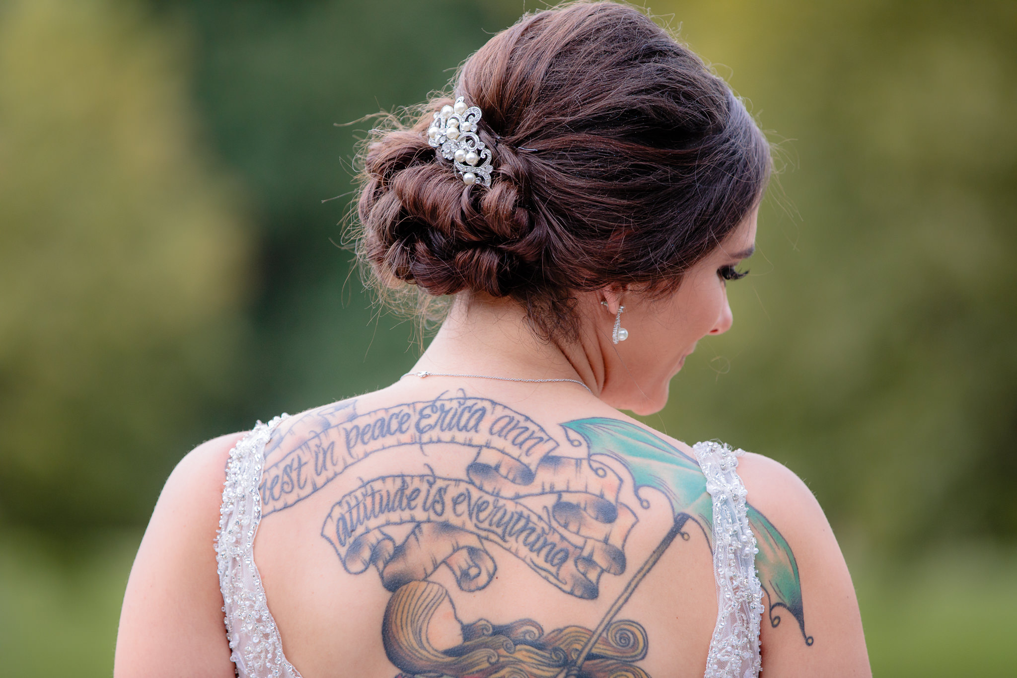 Bride's back tattoo shows through her backless wedding dress from The Exquisite Bride in Pittsburgh, PA