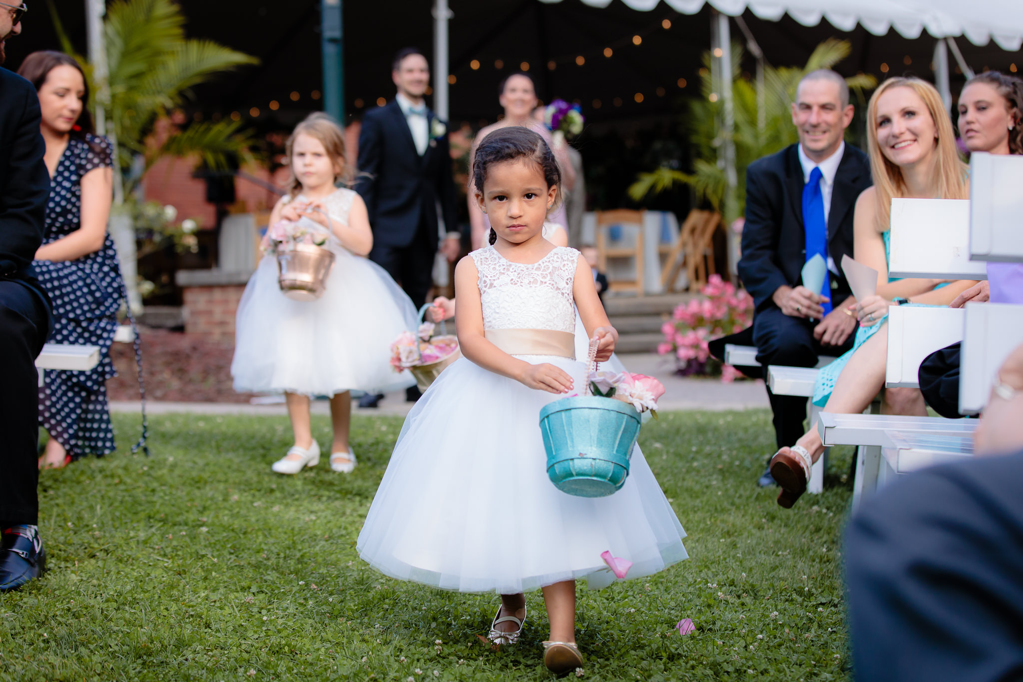 Flower girl walks down the aisle at an outdoor National Aviary wedding