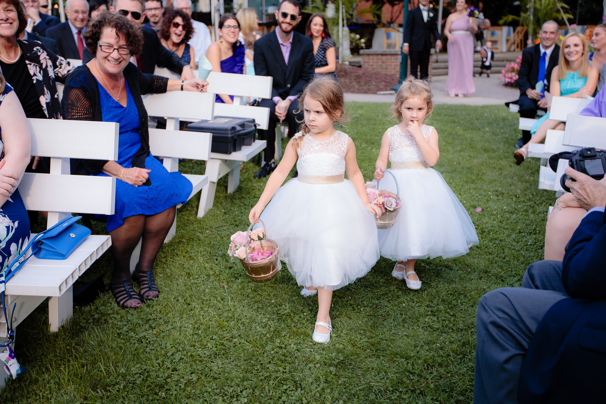 Flower girls walk down the aisle at an outdoor National Aviary wedding ceremony