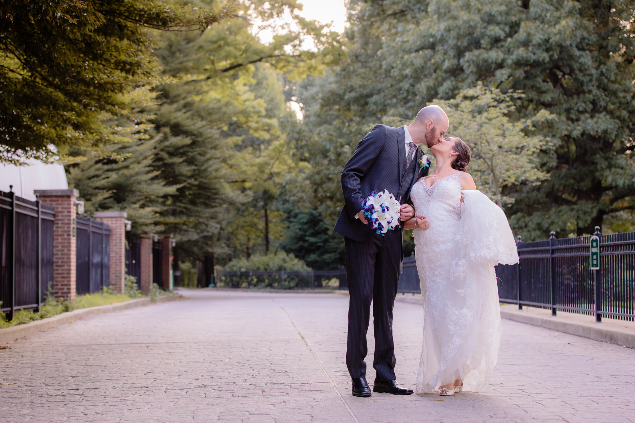 Newlyweds stroll down a cobblestone driveway at the National Aviary