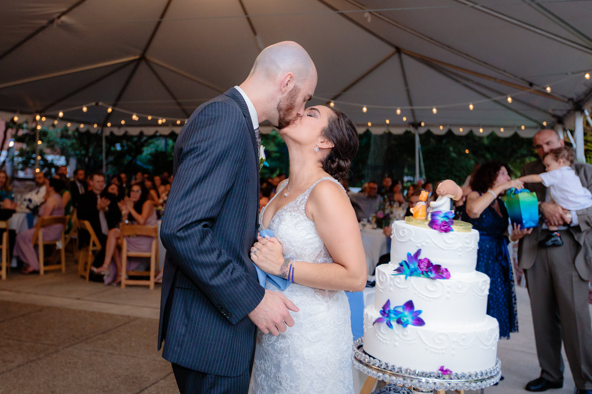 Bride & groom kiss after cutting their cake at the National Aviary