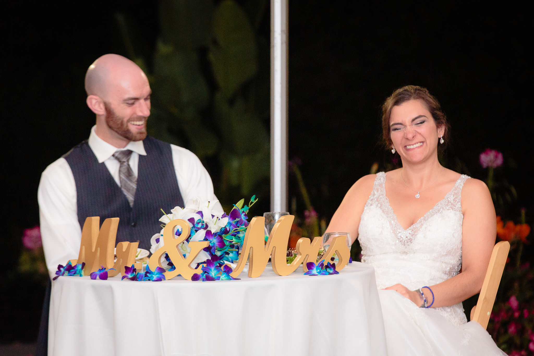 Newlyweds laugh during speeches at the National Aviary