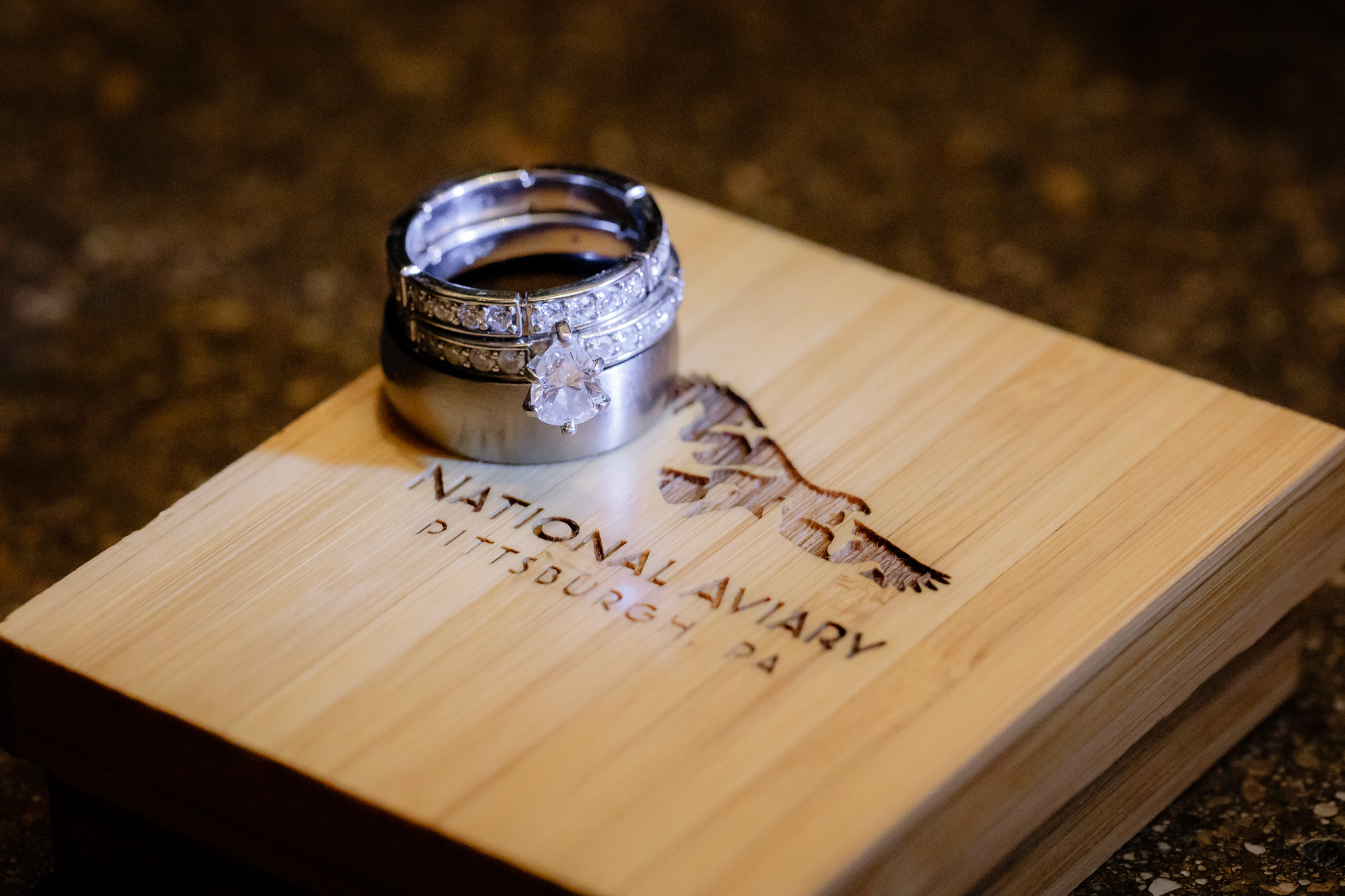 Wedding rings rest on a National Aviary wood box