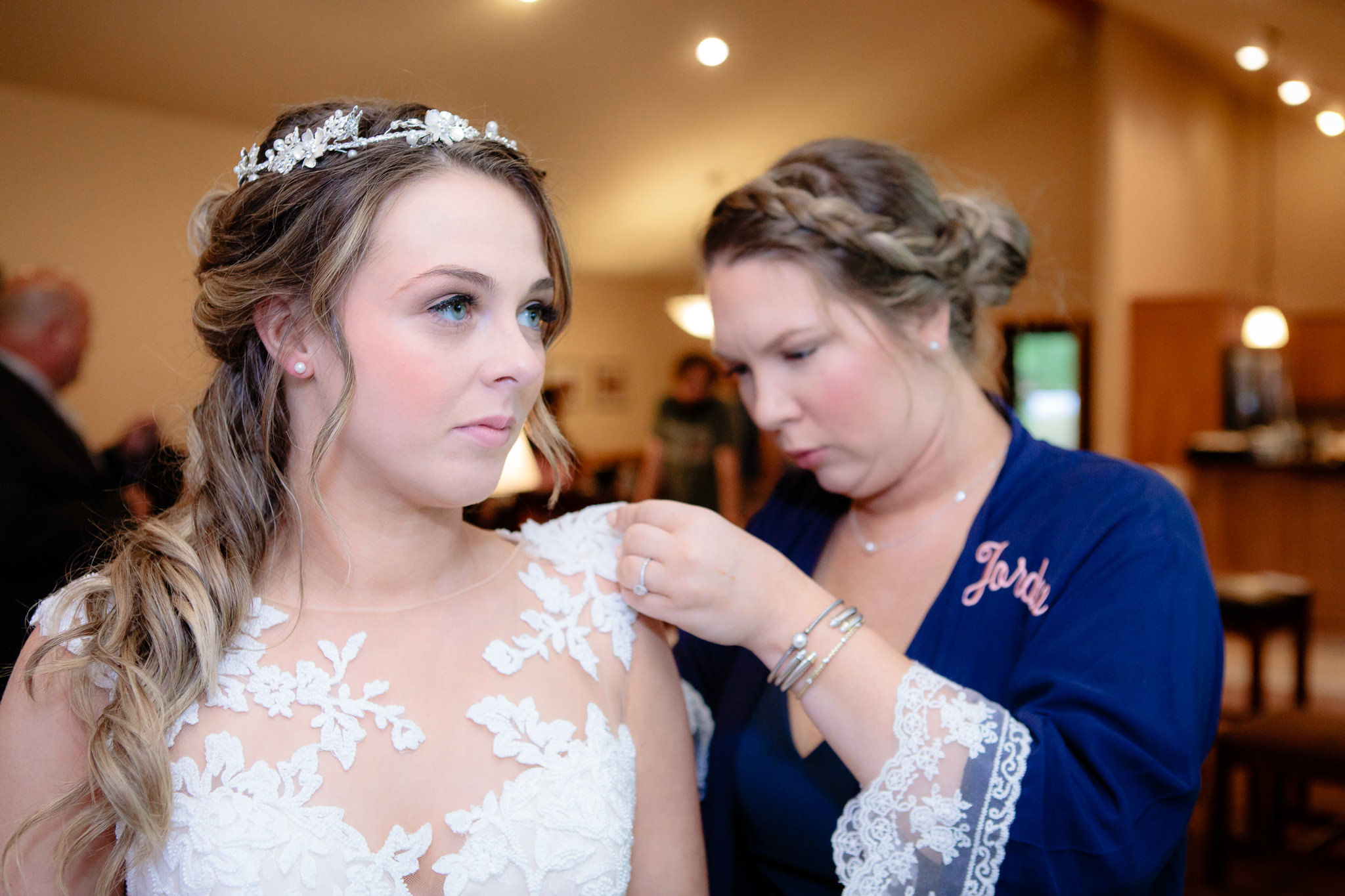 Maid of honor helps bride into her dress in May Cottage at Oglebay