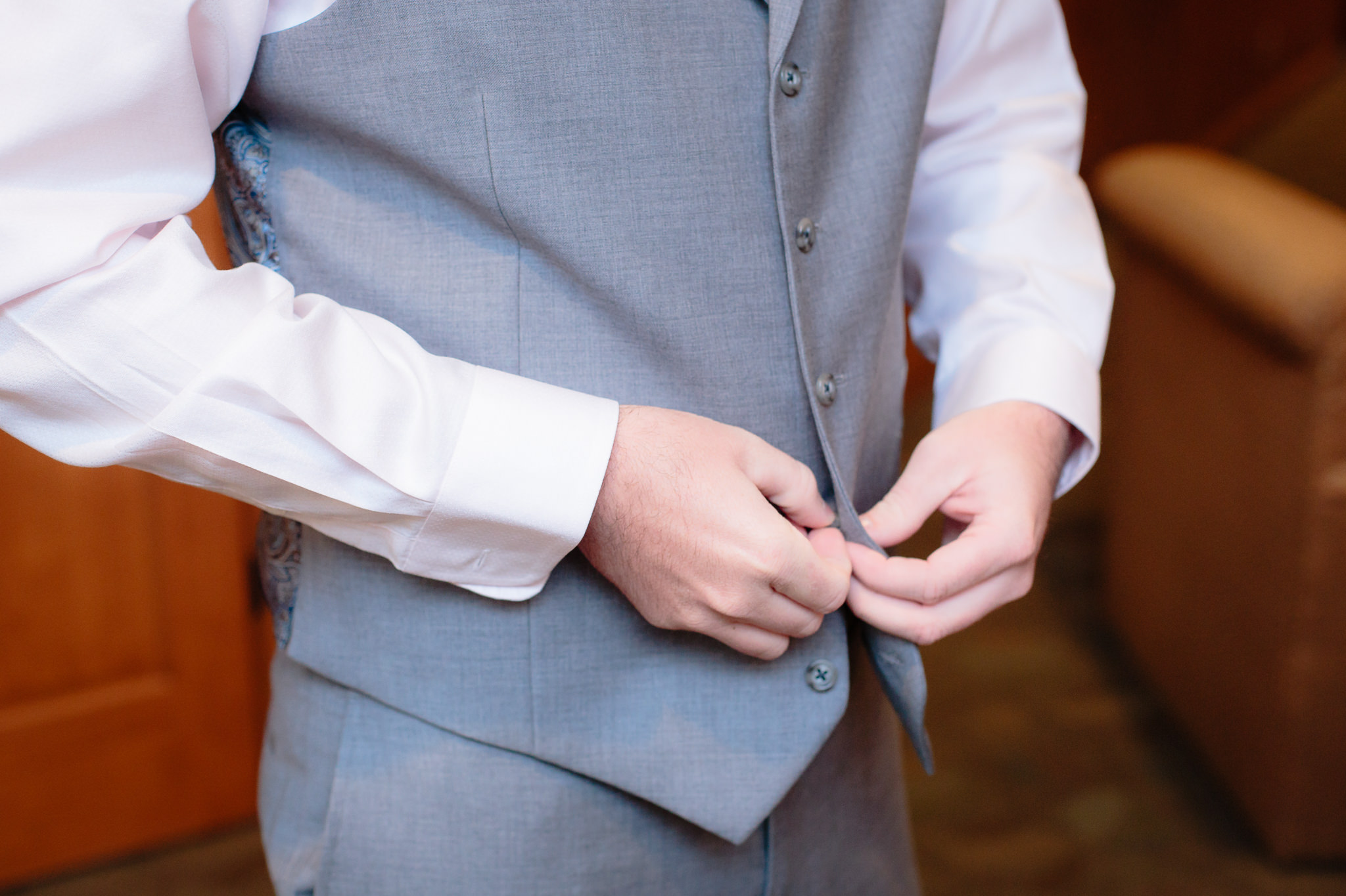 Groom buttons his Men's Wearhouse vest before his Oglebay wedding