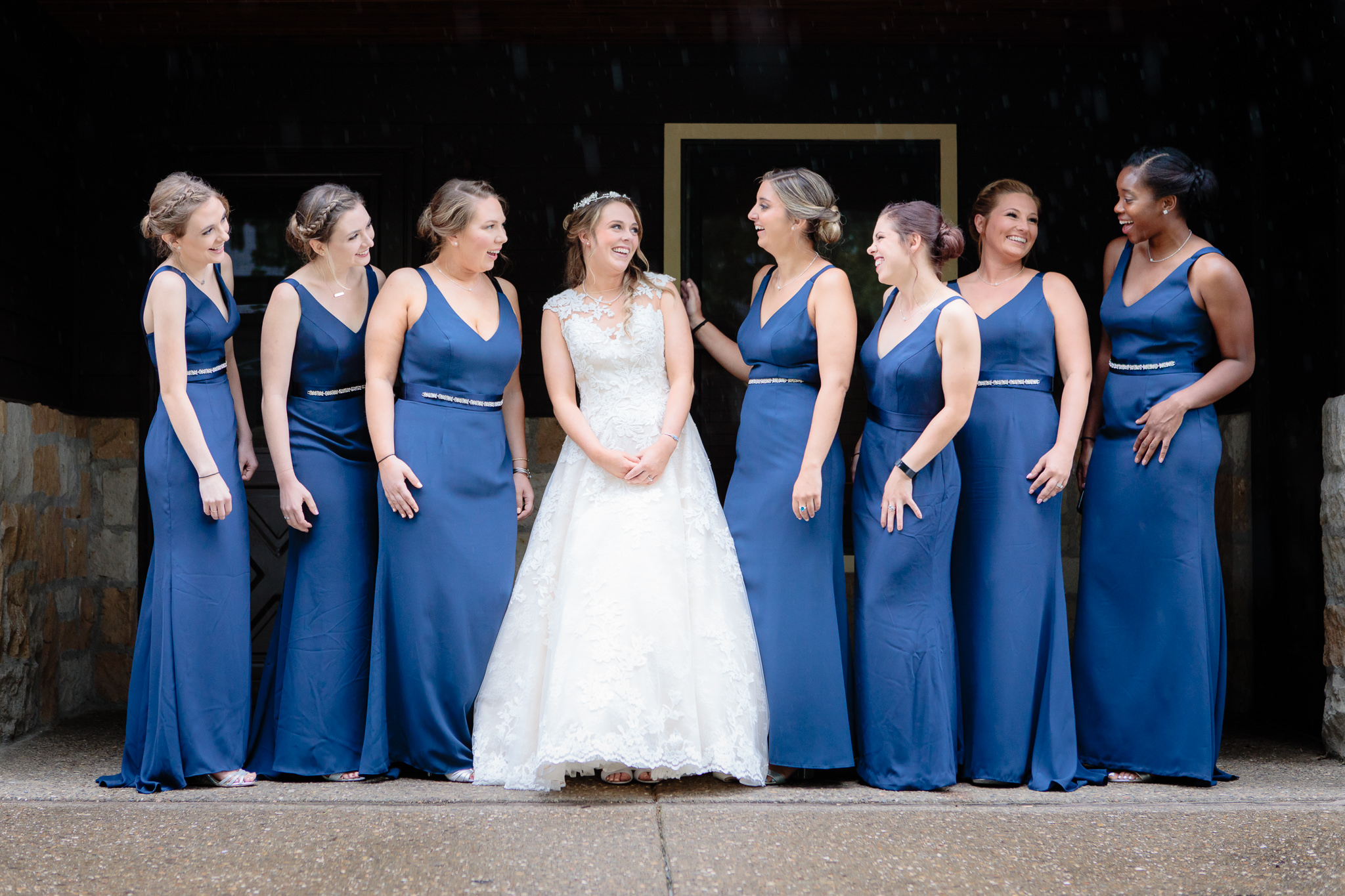 Bride & bridesmaids laugh together on the porch of May cottage at Oglebay