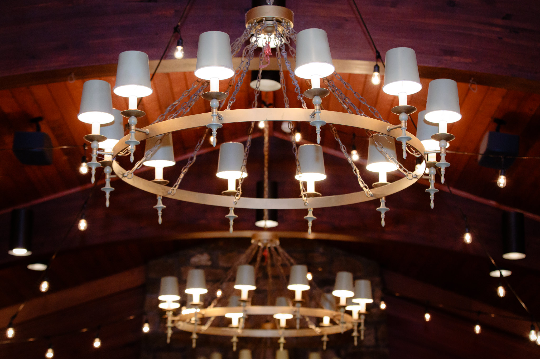 Chandeliers hang from the ceiling in the indoor wedding ceremony space at Oglebay
