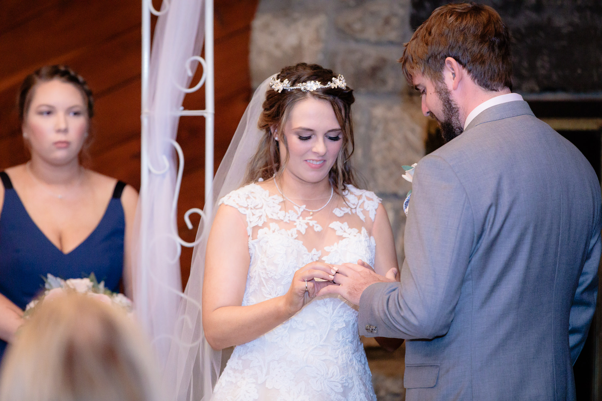 Bride places the wedding band on her groom's finger during their Oglebay wedding ceremony