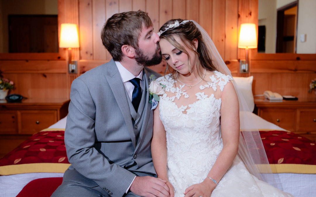 Groom kisses his bride's forehead in the presidential suite at Oglebay