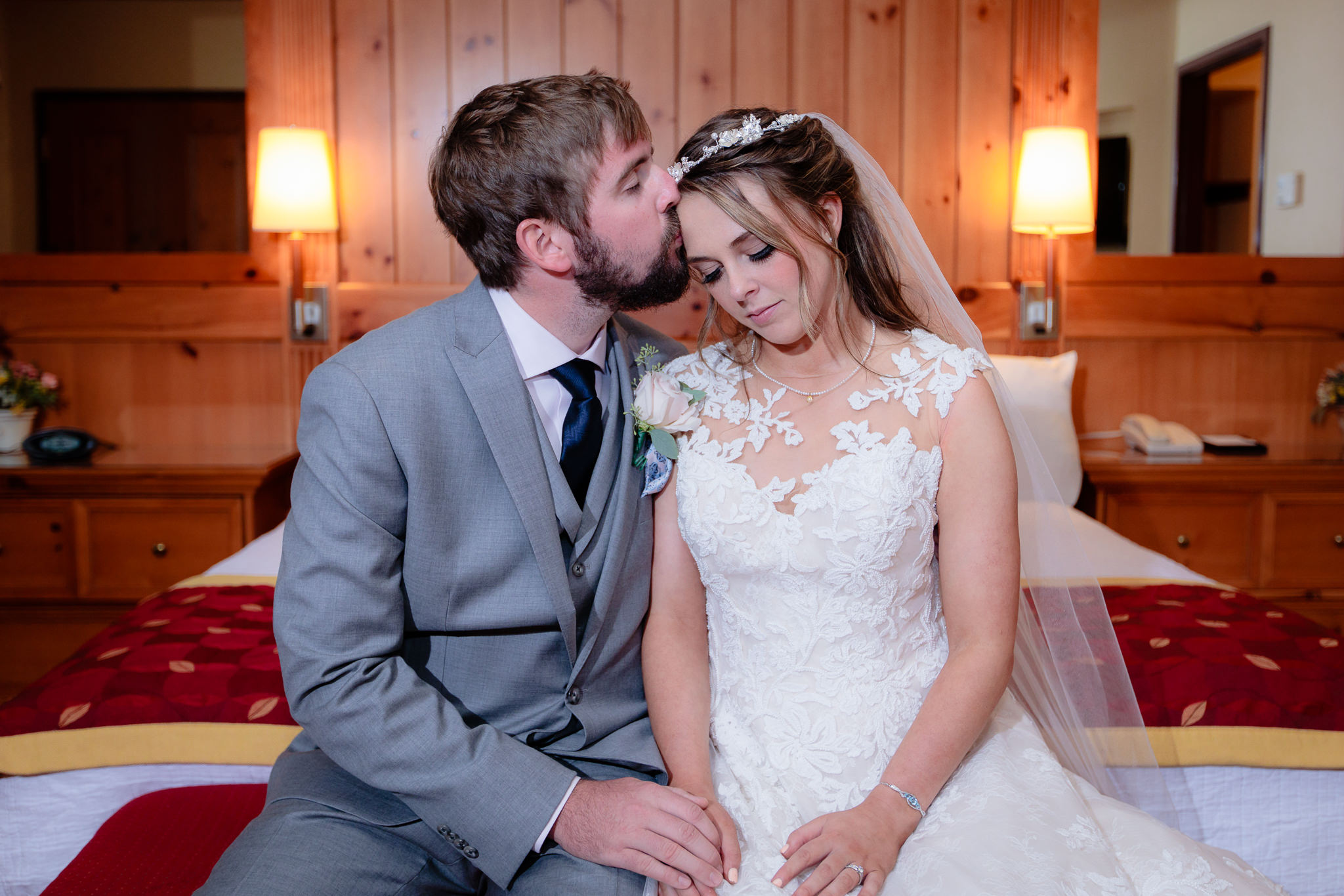 Groom kisses his bride's forehead in the presidential suite at Oglebay