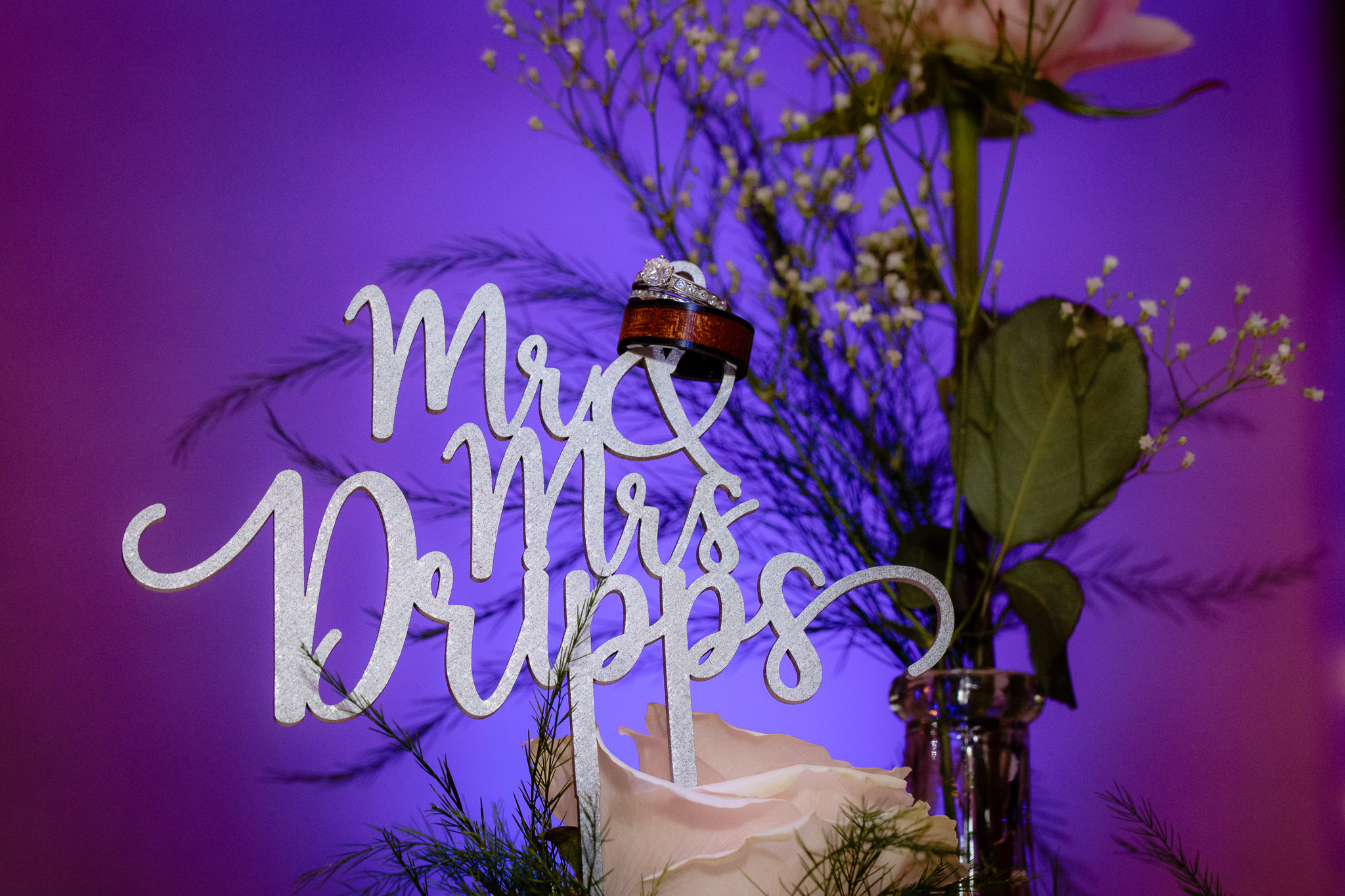 Wedding rings rest on top of a Mr. & Mrs. cake topper at an Oglebay wedding