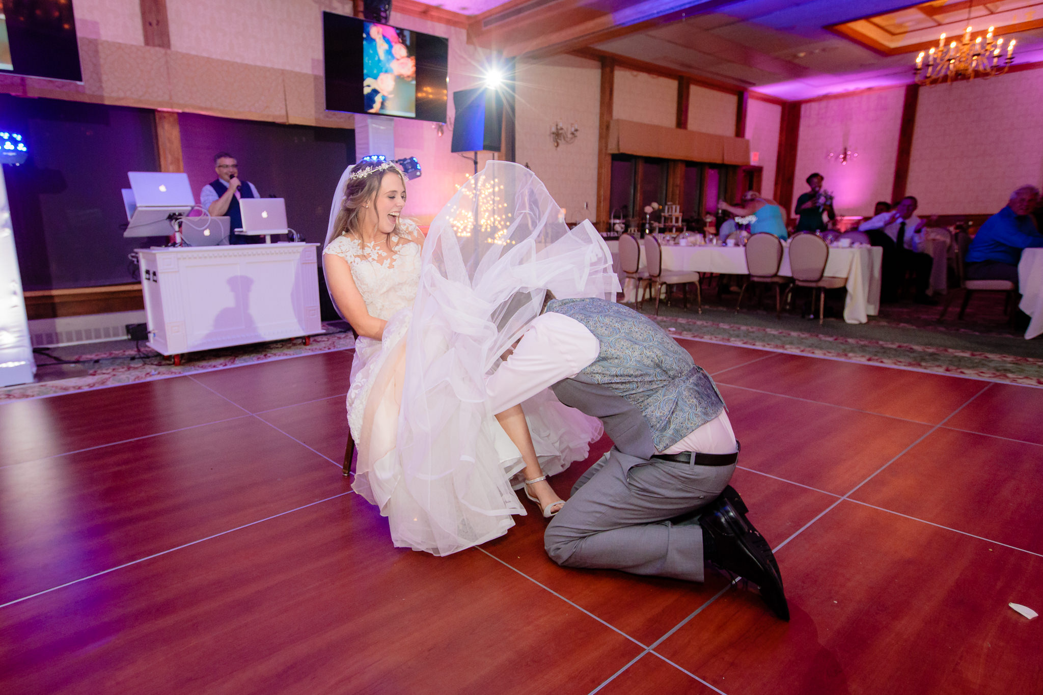 Groom removes the garter from his bride's leg at Oglebay