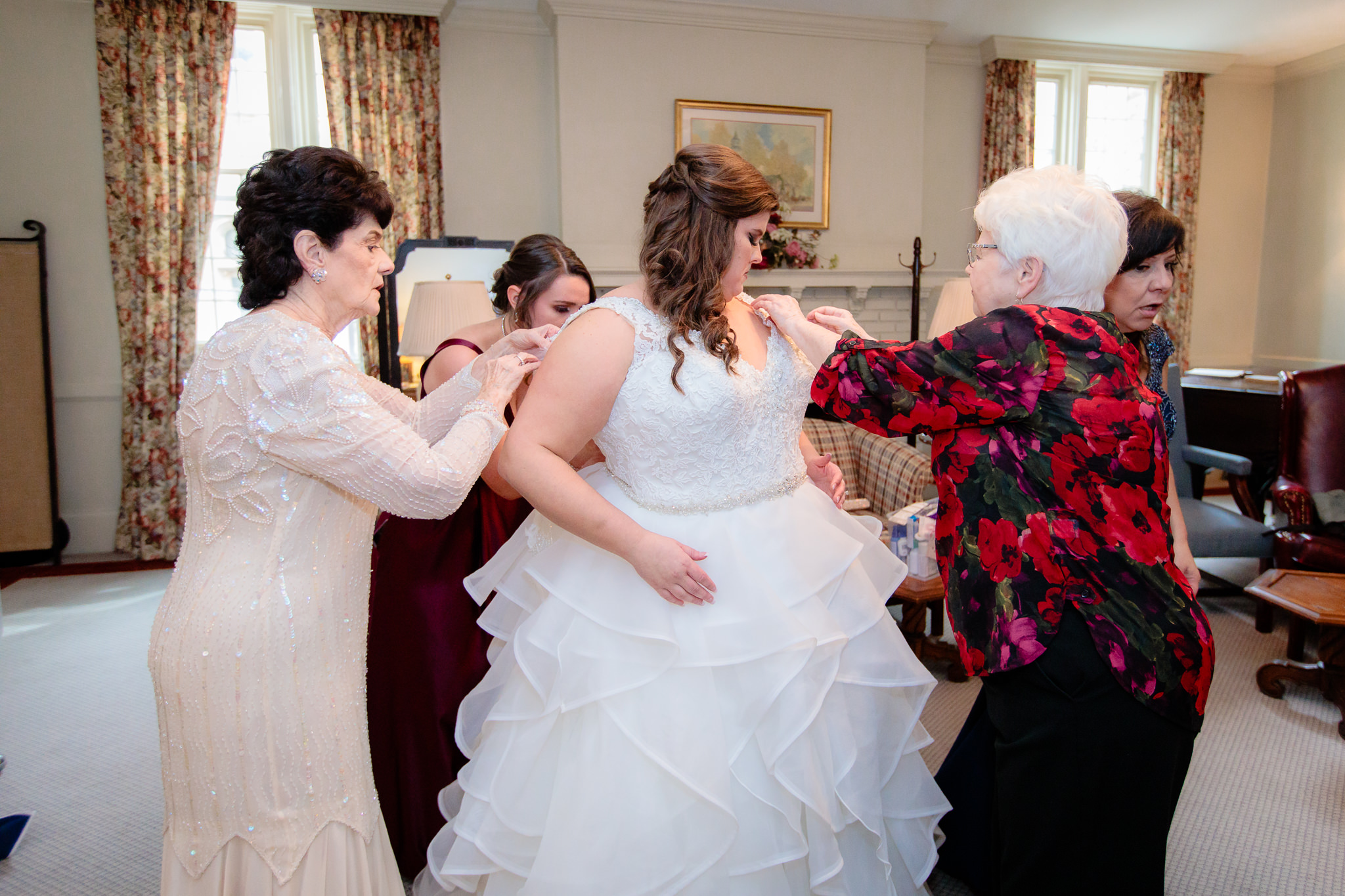 The bride and her family adjusting the straps of her wedding gown in Mt. Lebanon United Methodist Church