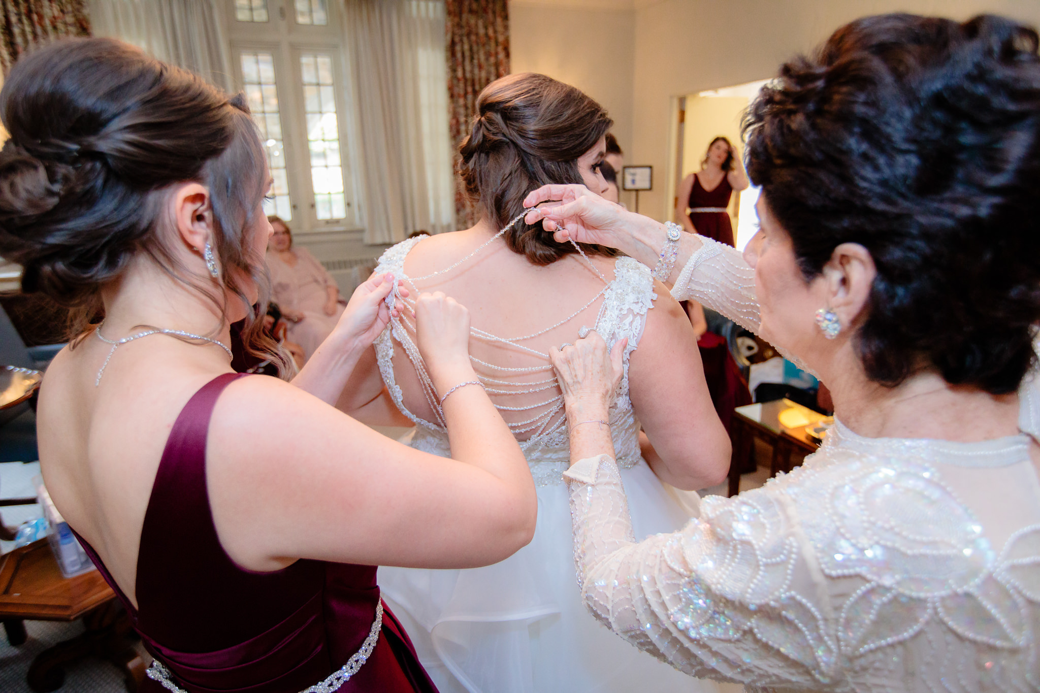 A bridesmaid helps lace up the back of the bride's dress for a wedding at Mt. Lebanon United Methodist Church