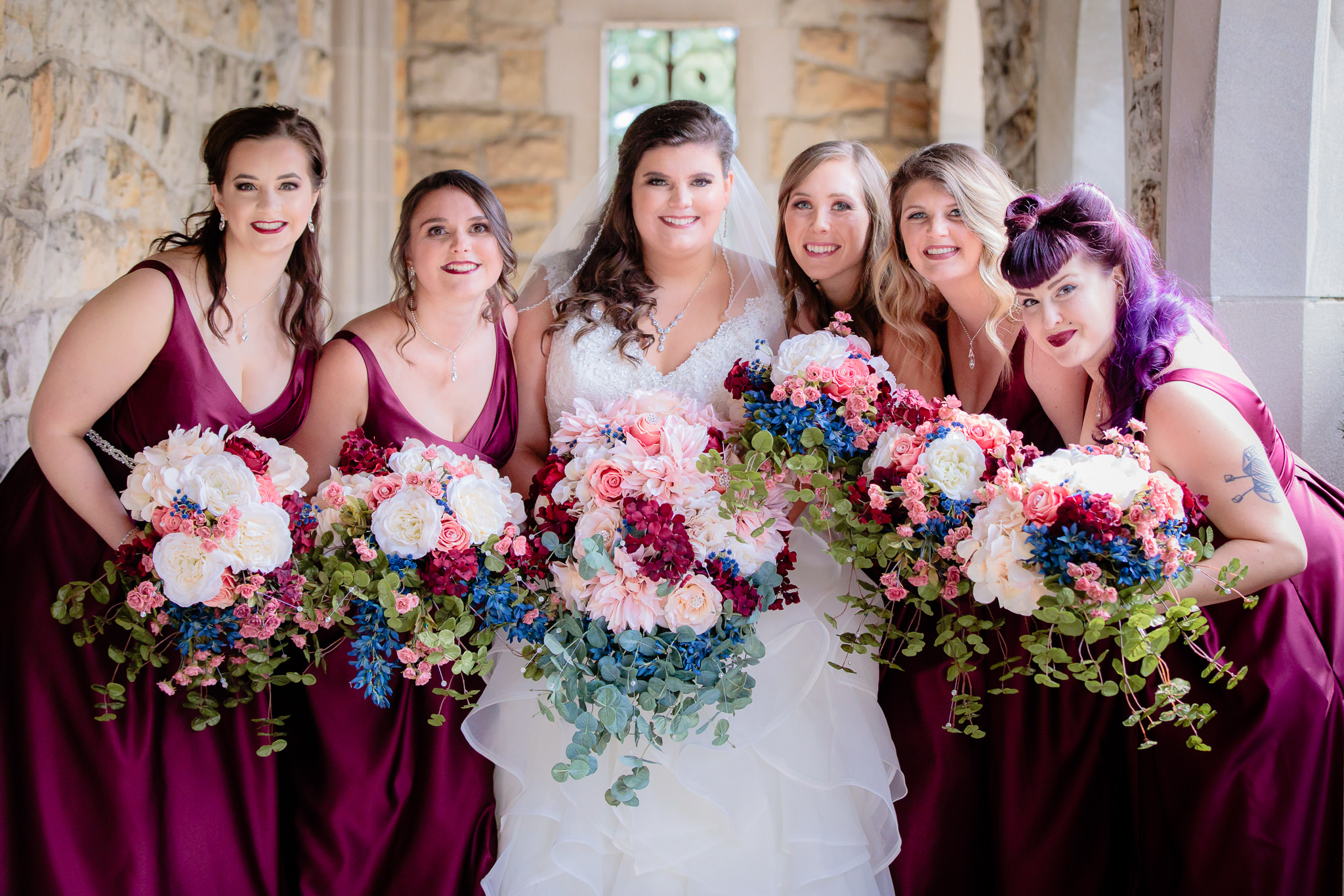 The bridal party in plum dresses with the bride outside of Mt. Lebanon United Methodist Church