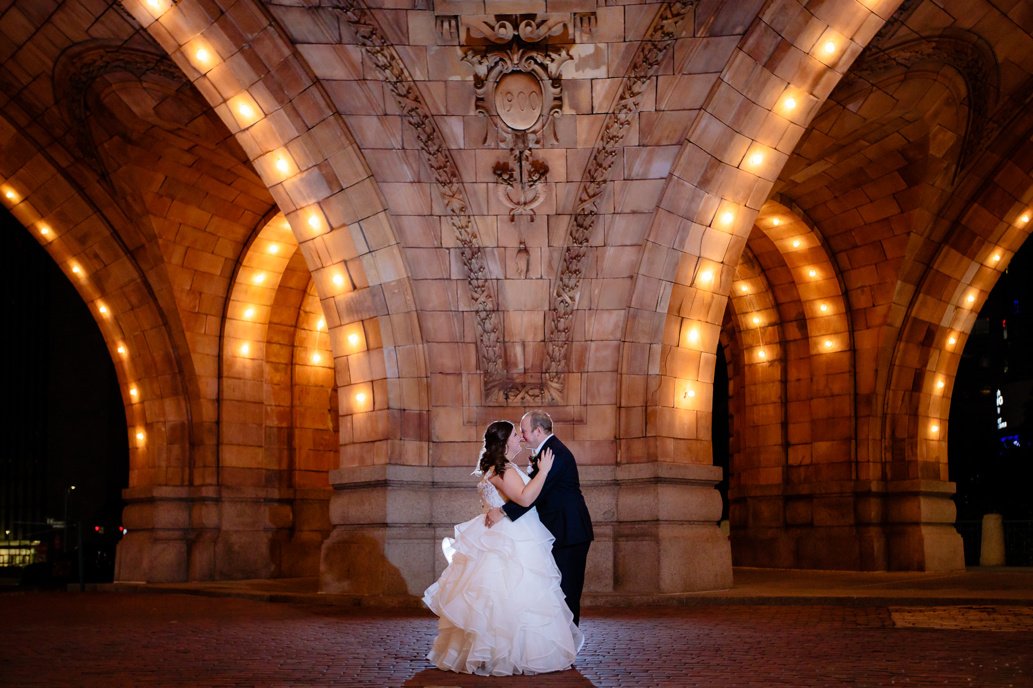 Bride and groom kiss outside of The Pennsylvanian at night