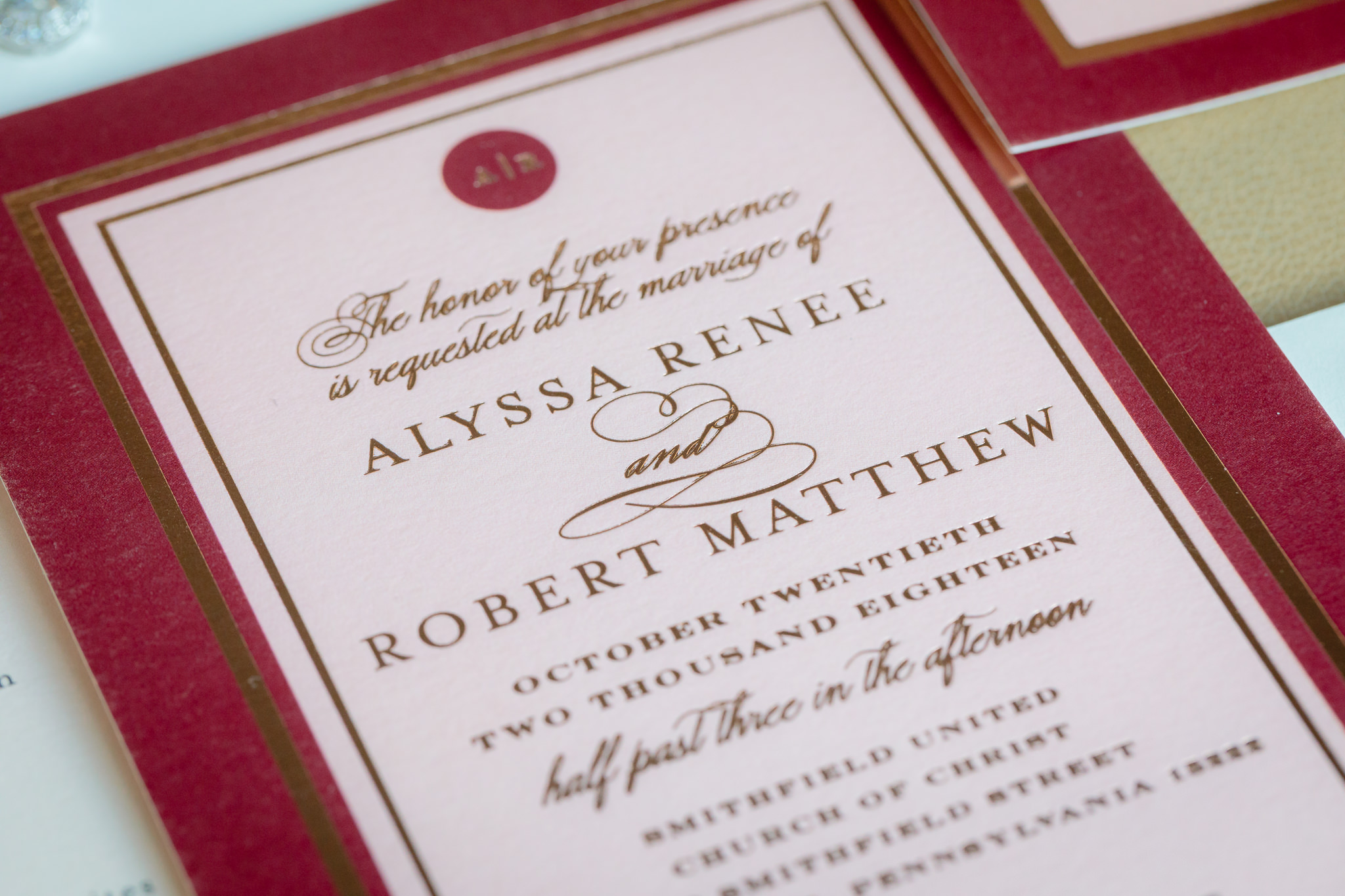 Closeup of burgundy and pink wedding invitations by Minted