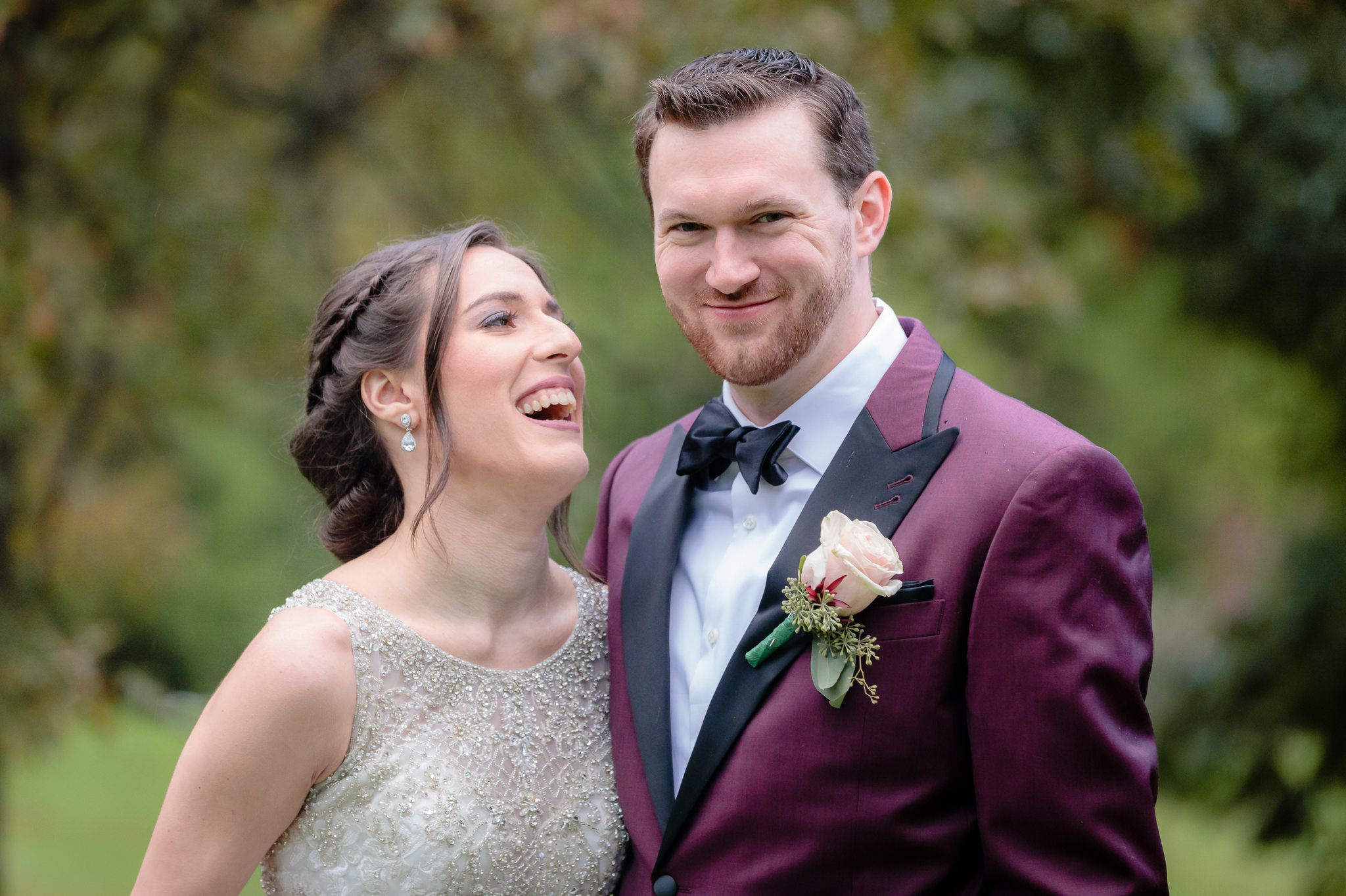 Bride laughs and groom smirks during portraits in Allegheny Commons Park