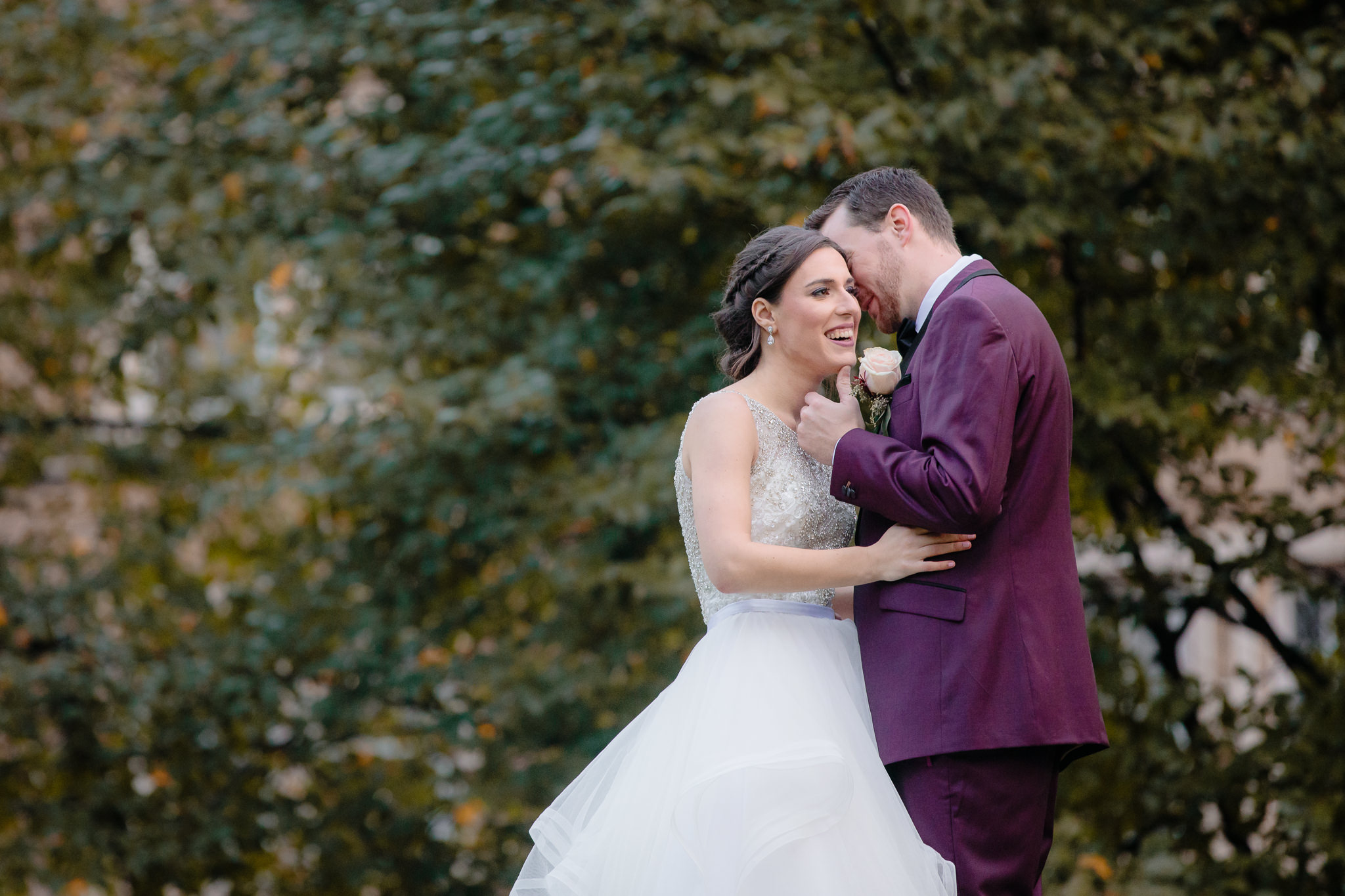 Bride laughs as groom whispers in her ear in Allegheny Commons Park in the North Side
