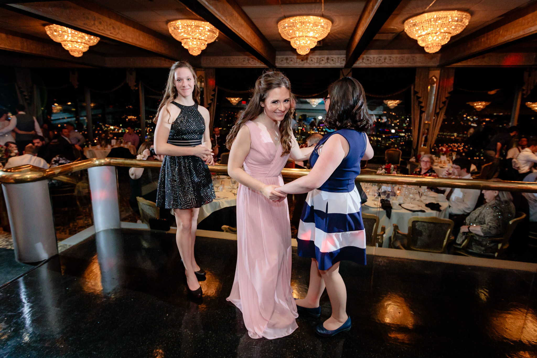 Bridesmaid dances with her sisters at a LeMont wedding
