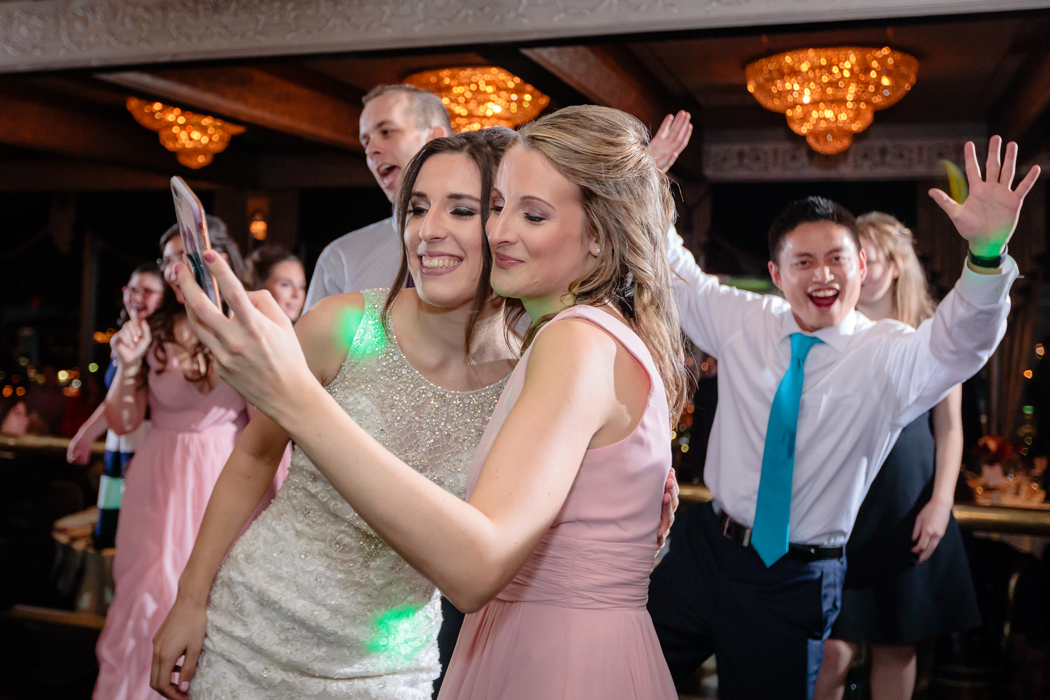 Bride takes a selfie with a bridesmaid at her LeMont wedding