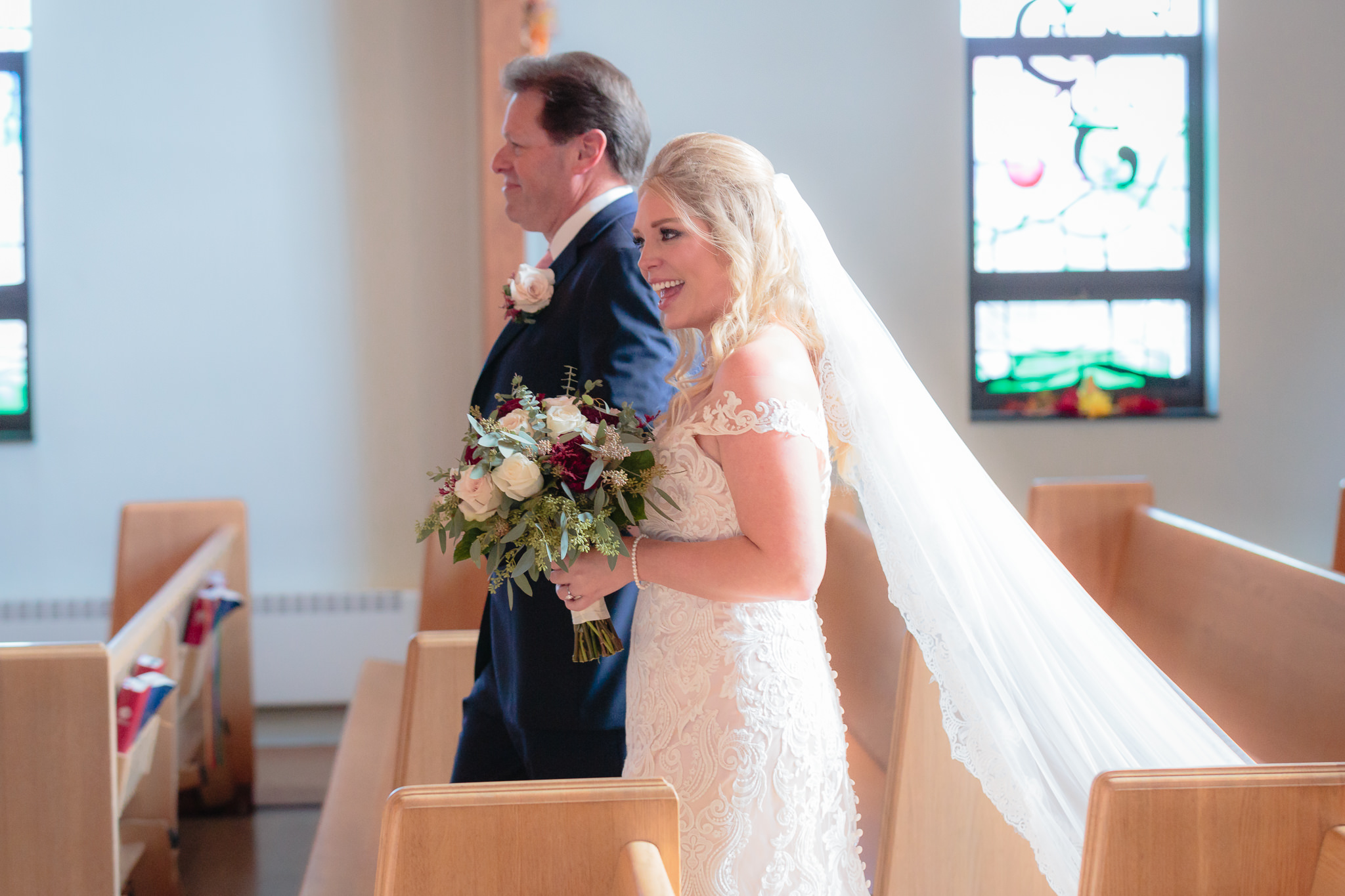 Bride smiles as she walks down the aisle at Zion Lutheran Church in Penn Hills