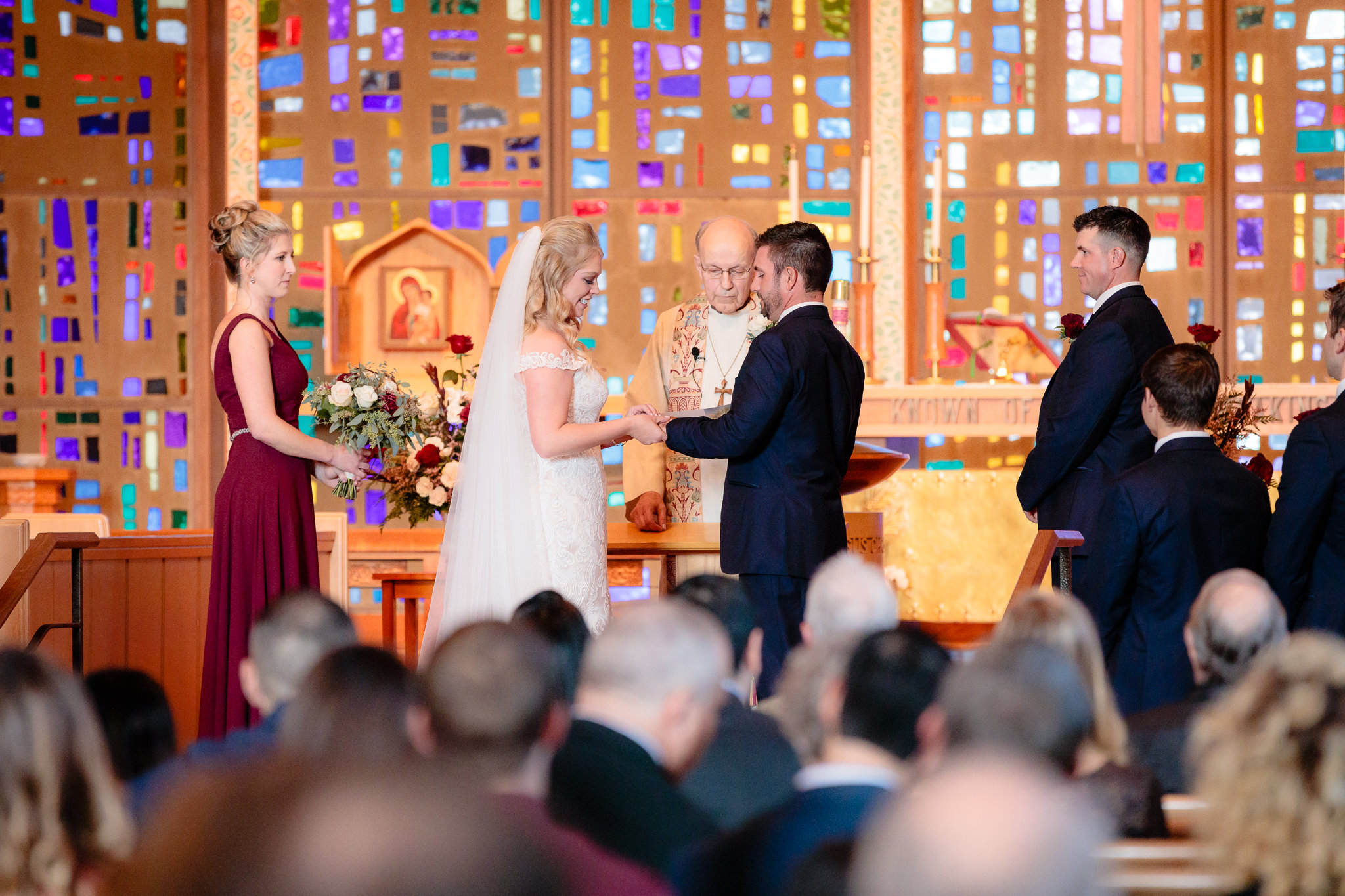Bride places ring on groom's finger during ceremony at Zion Lutheran Church