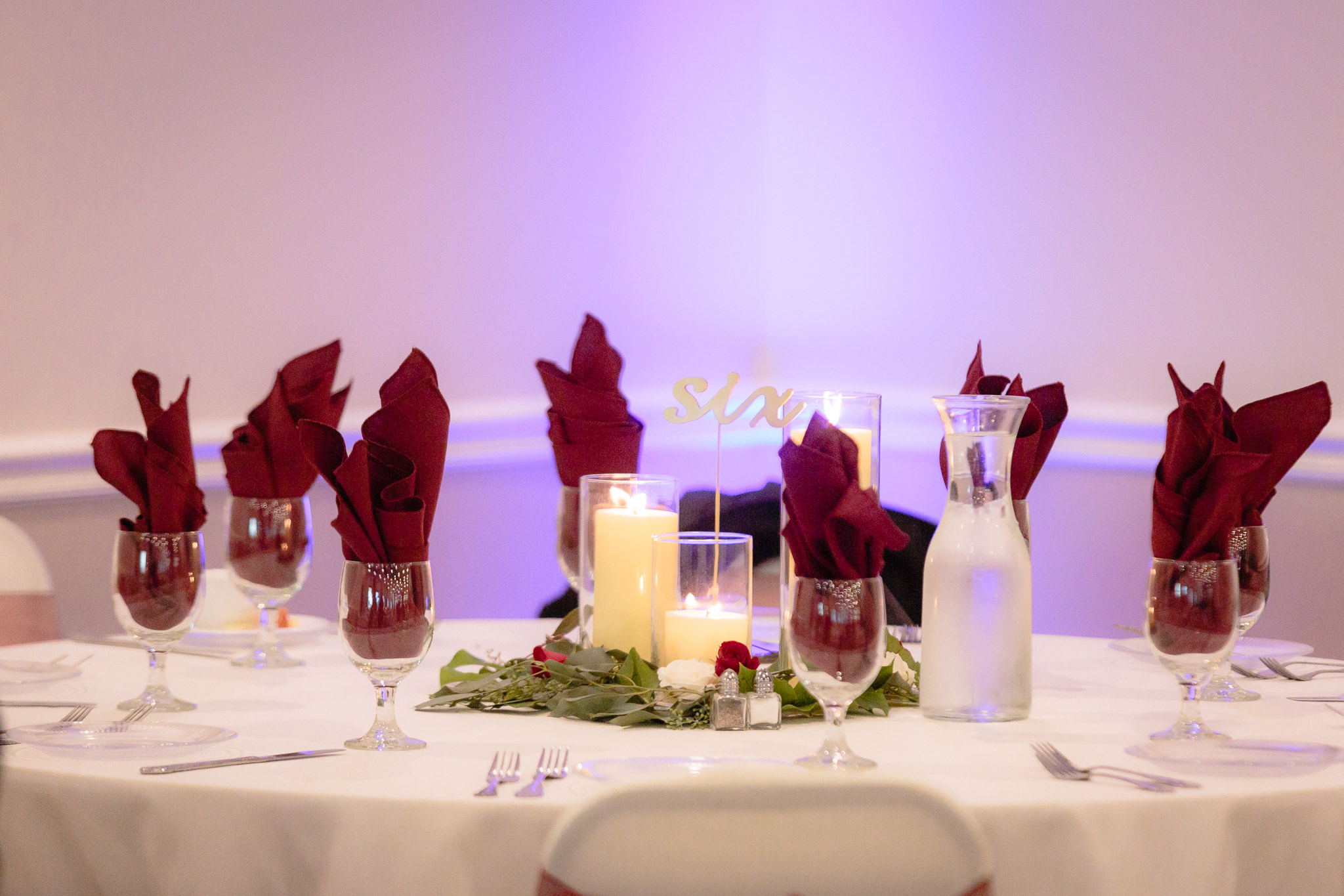 Table setting with purple uplighting at a Riverside Landing wedding reception