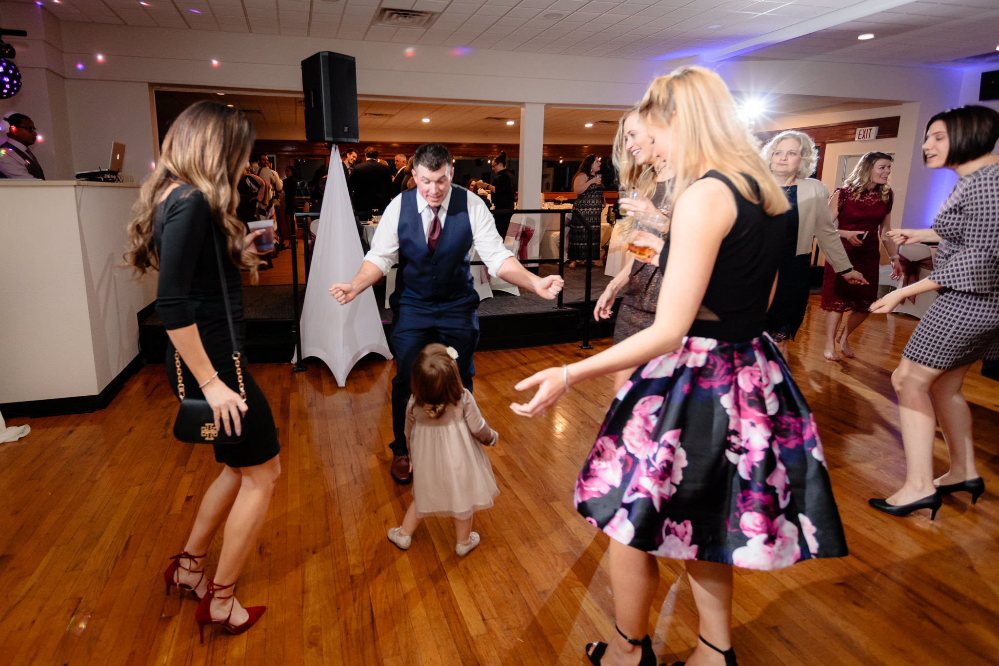 Groomsman dances with a little girl at a Riverside Landing wedding