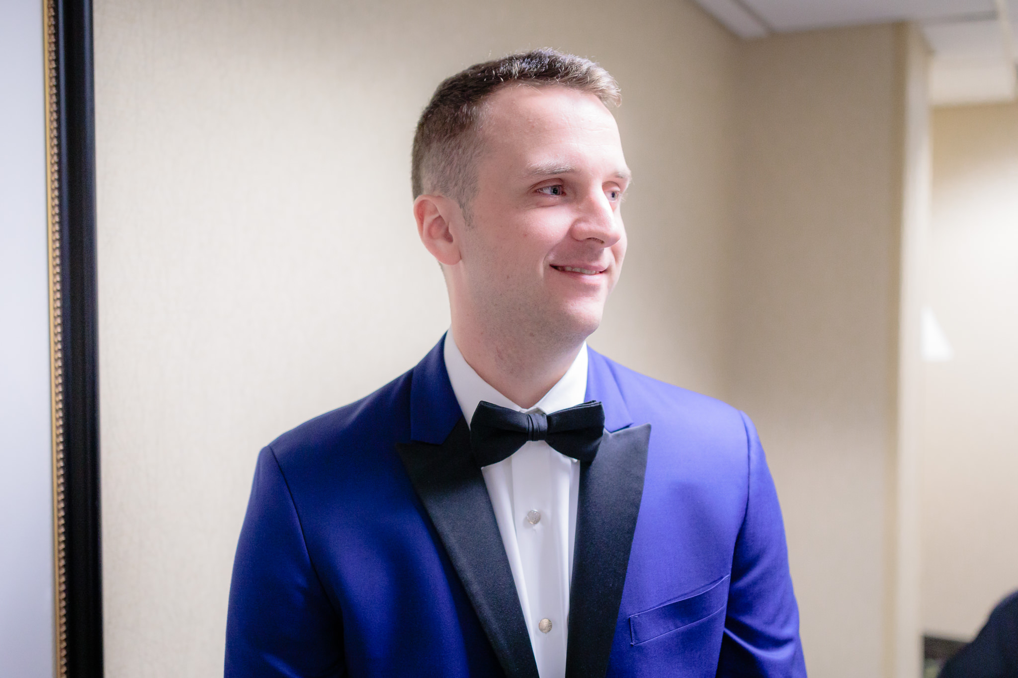 Groom in a blue Ike Behar tuxedo from Tuxedo Junction before his Saint Paul Cathedral wedding