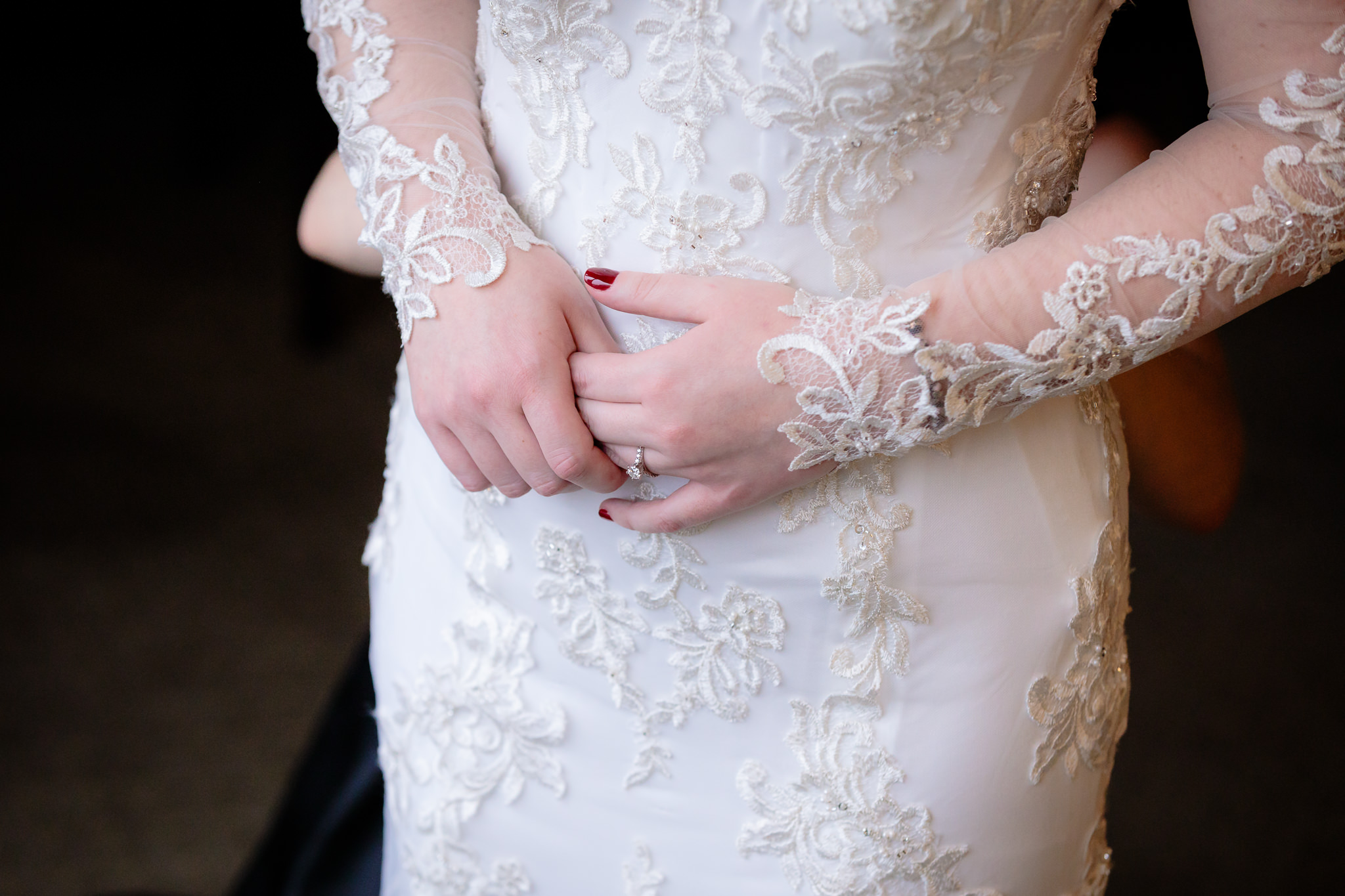Bride's hands rest against her wedding dress as she prepares for her Saint Paul Cathedral wedding