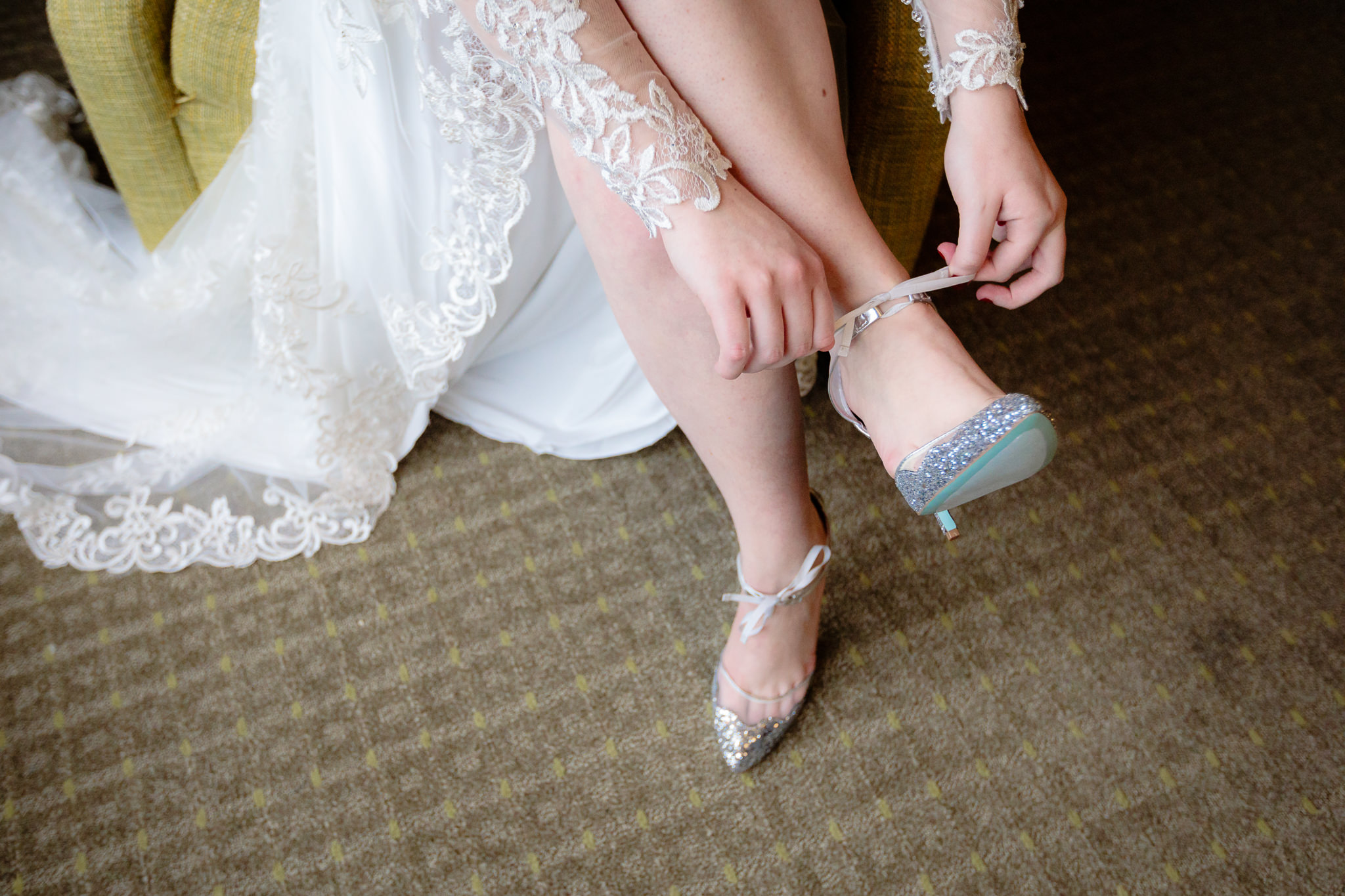 Bride ties the ankle of her shoes before a Saint Paul Cathedral wedding