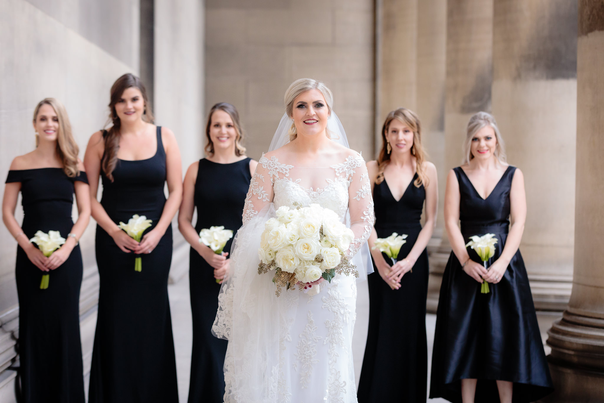 Bride in a Sottero & Midgley wedding dress with her bridesmaids in black dresses