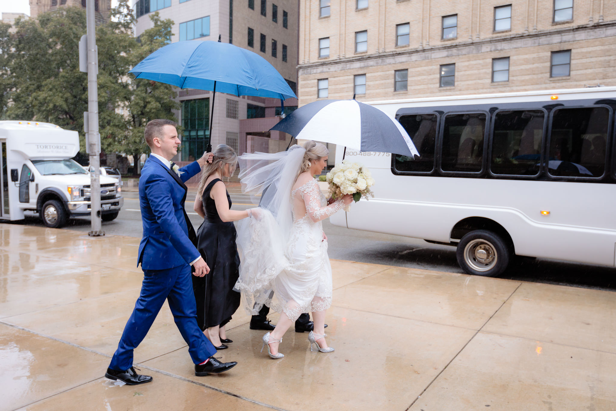 Newlyweds walk to the limo in the rain before their Soldiers & Sailors wedding