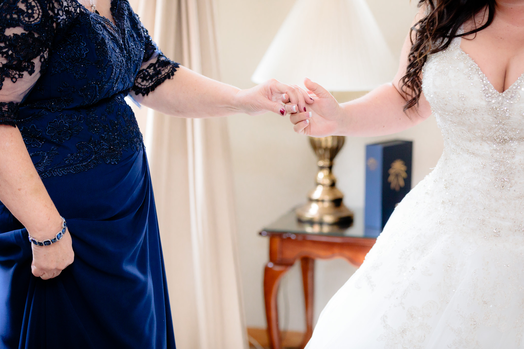 Bride holds hands with her mother while getting ready for her St. Malachy wedding