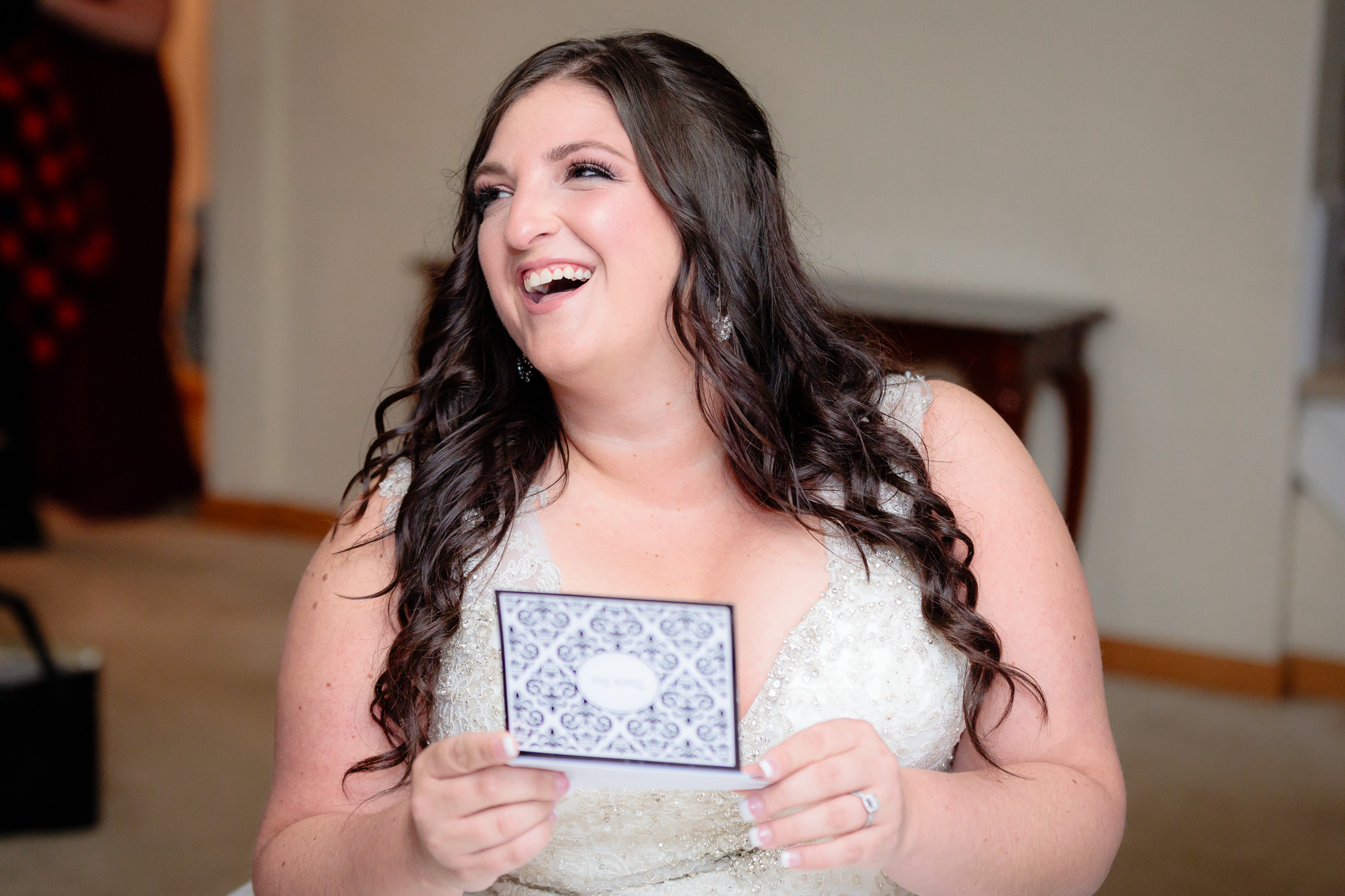 Bride laughs as she reads a letter from the groom before their St. Malachy wedding ceremony