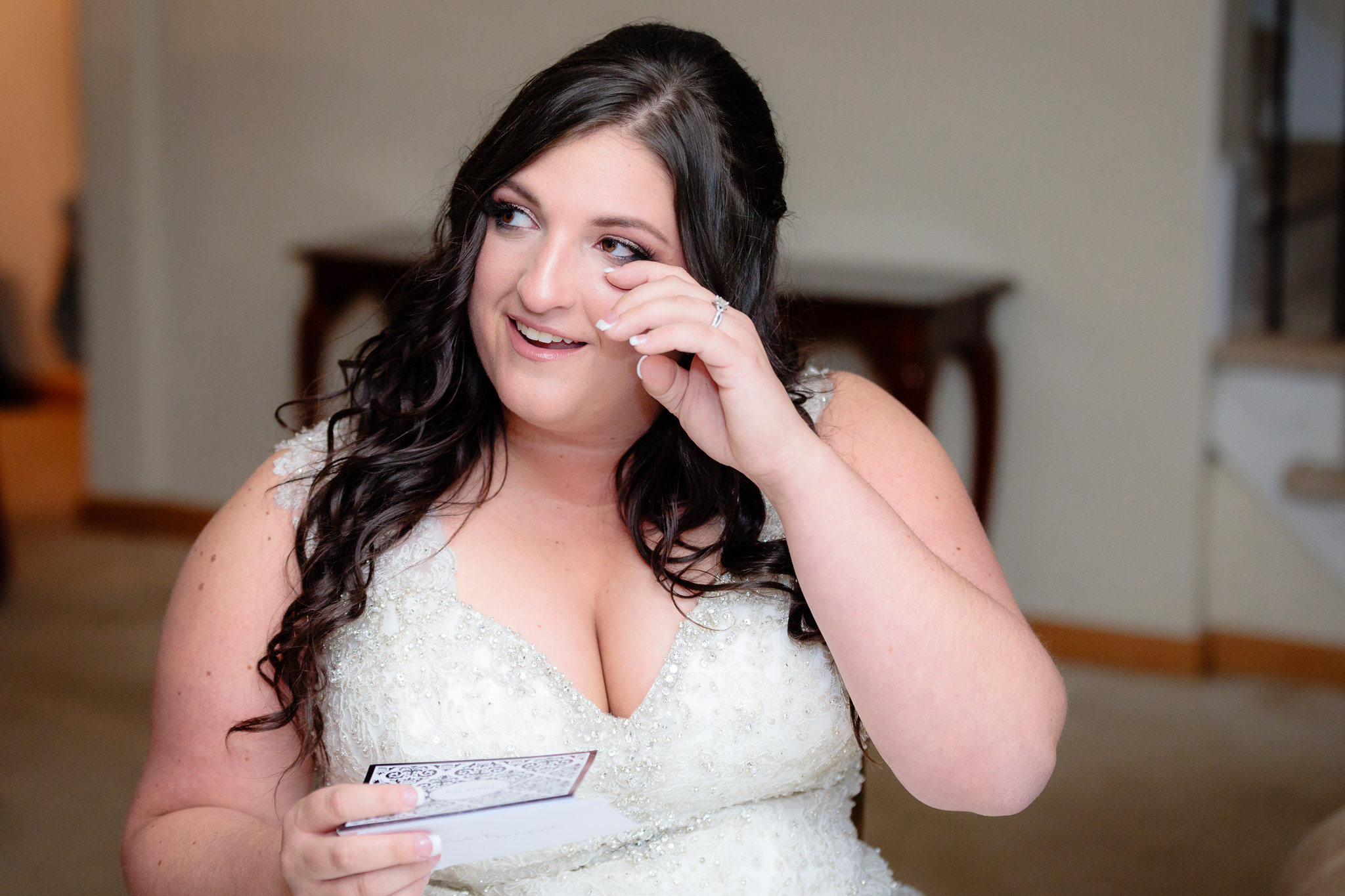 Bride wipes a tear from her eye as she reads a letter from her groom